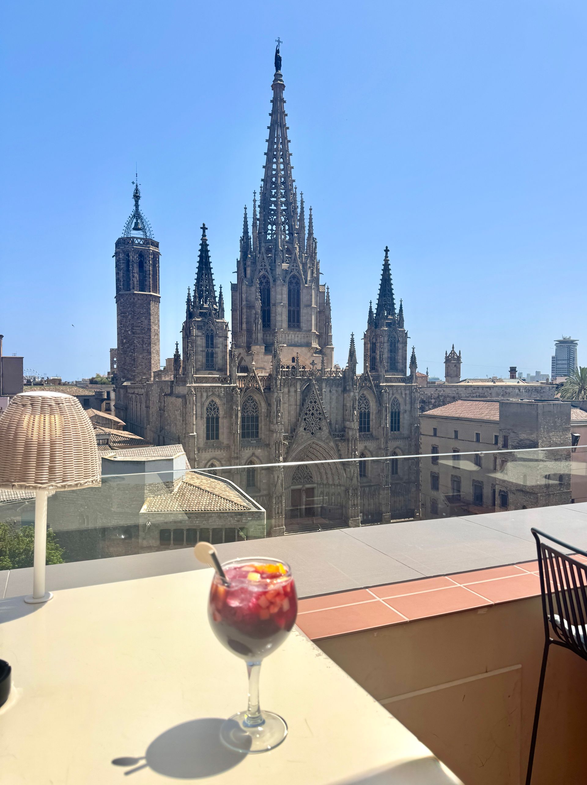 Cocktail on rooftop overlooking Gothic Cathedral in Barcelona, Spain, on a sunny day.