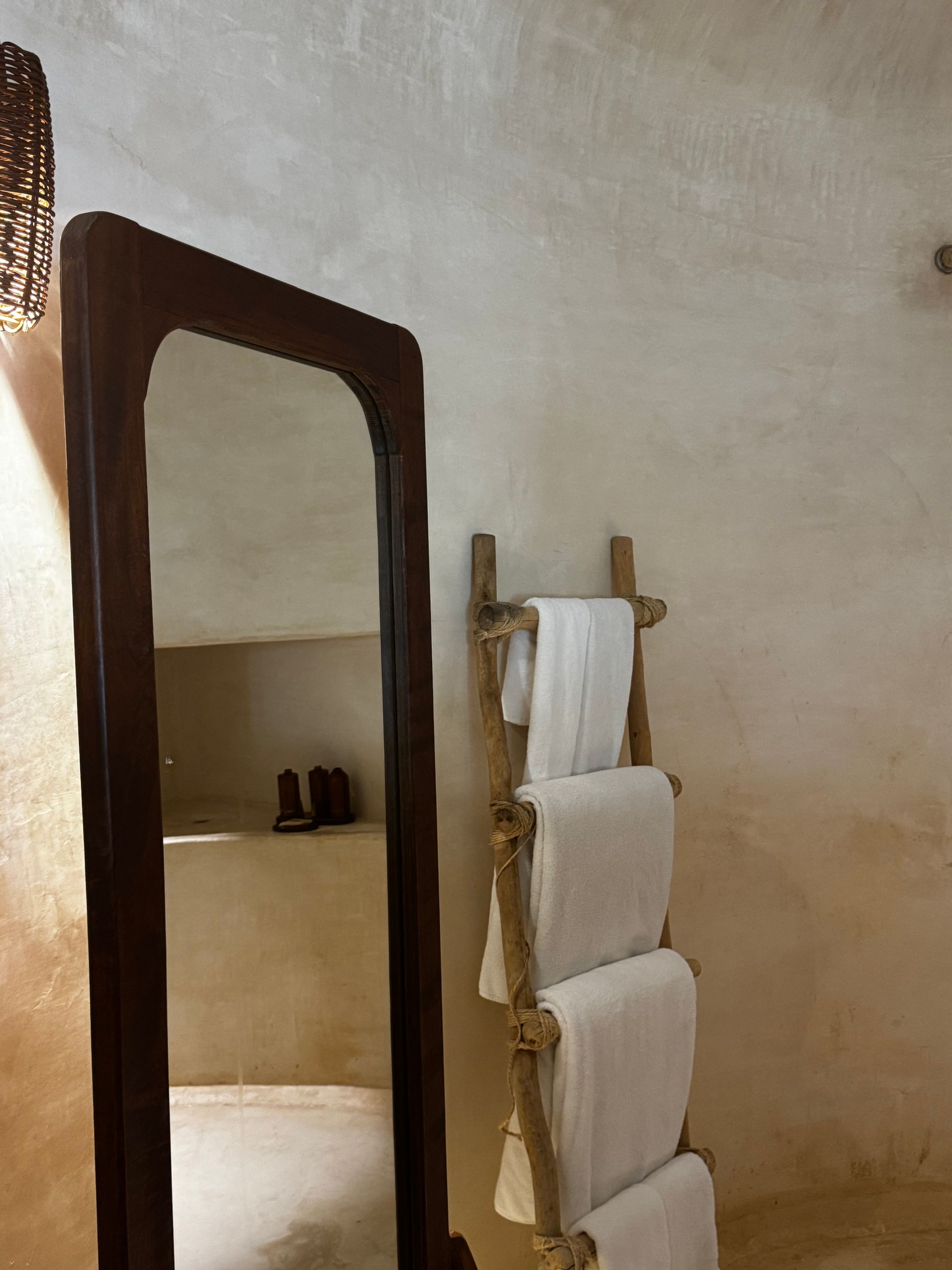 A bathroom with a towel rack and a mirror at Papaya Playa Project hotel in Tulum, Mexico.