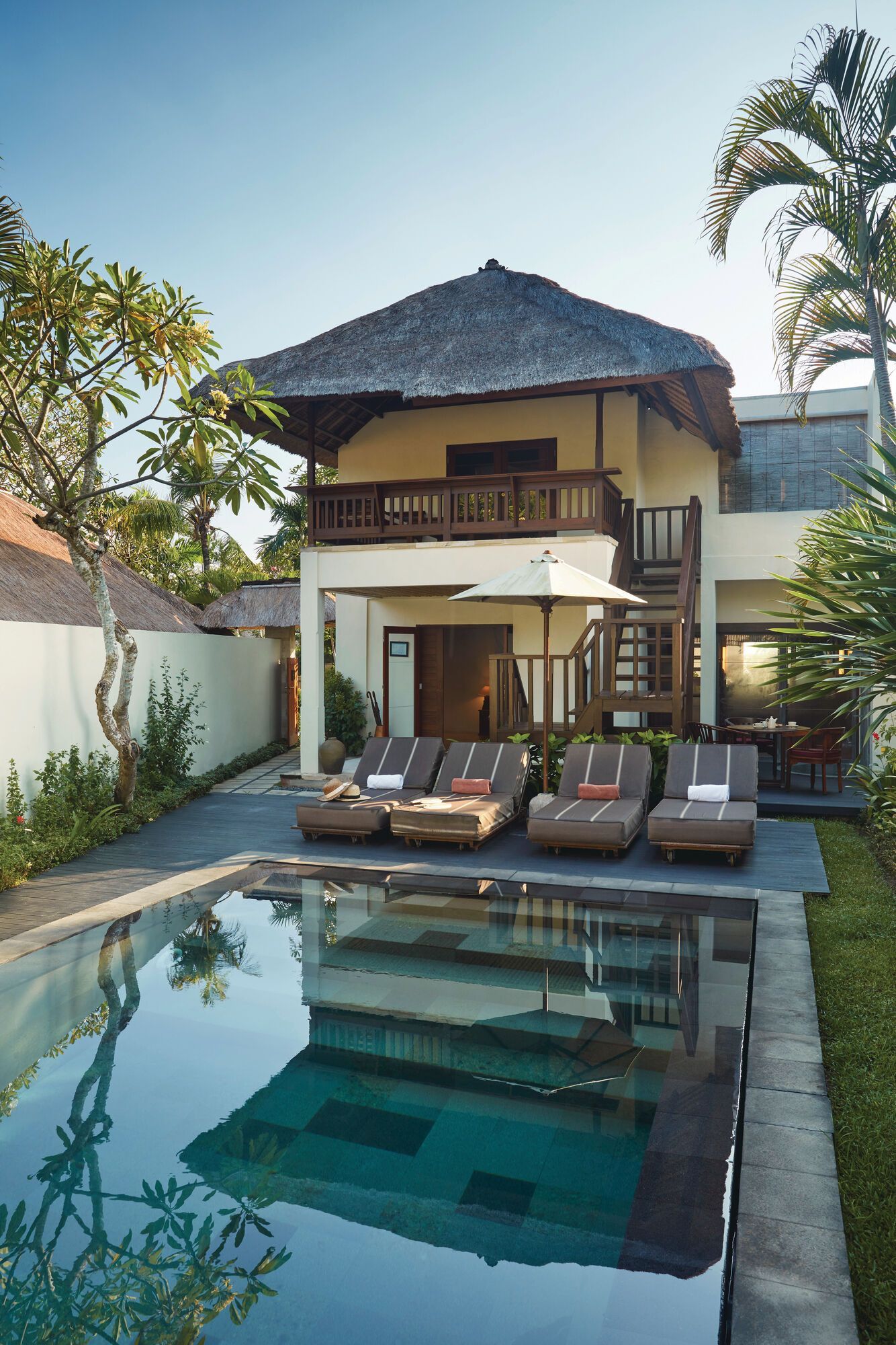 A large villa with a swimming pool in front of it in Bali.