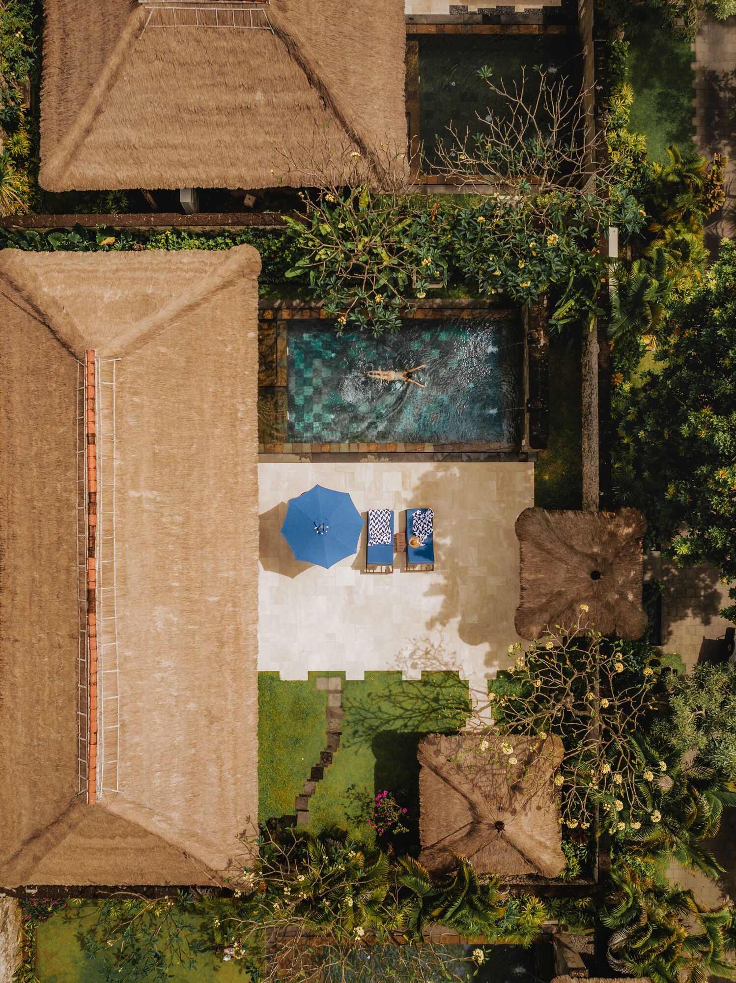 An aerial view of a villa with a swimming pool and chairs in Bali.