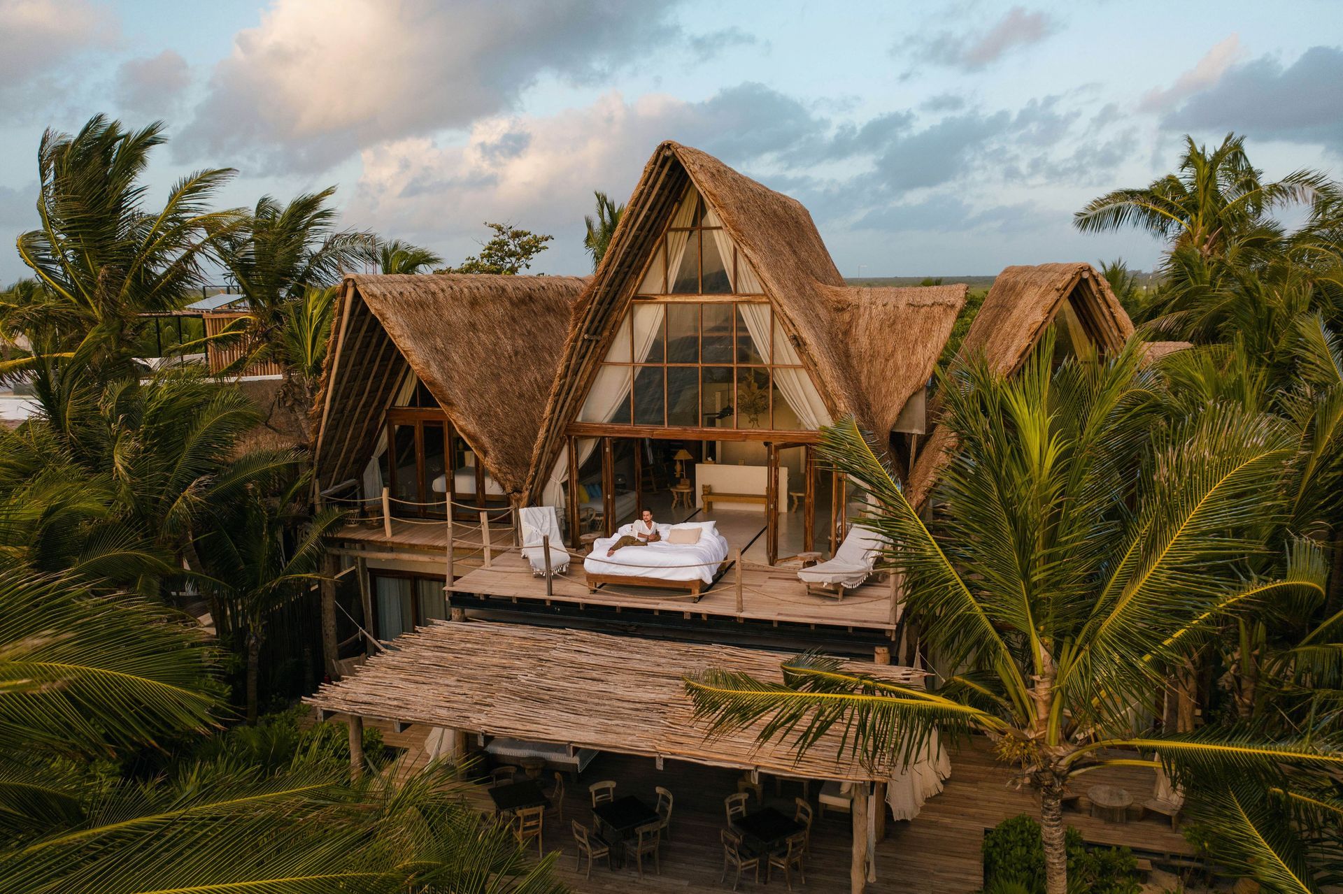 An aerial view of a thatched house surrounded by palm trees at La Valise Tulum Hotel in Mexico.