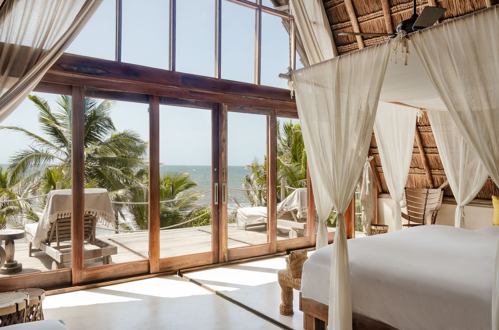 A bedroom with a canopy bed and a view of the ocean at La Valise Tulum hotel in Mexico.