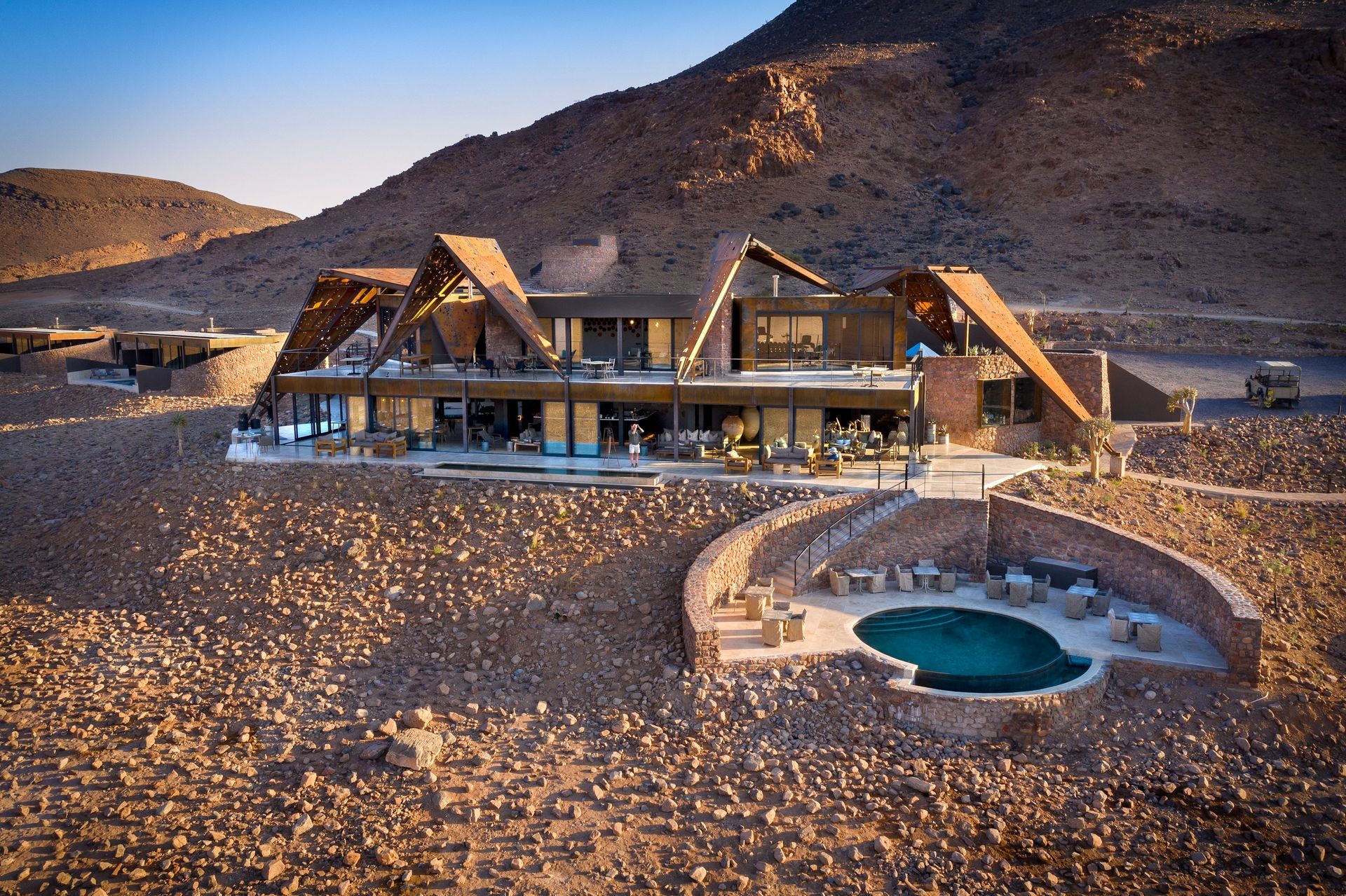 A large lodge with a pool in the middle of the desert in Africa.