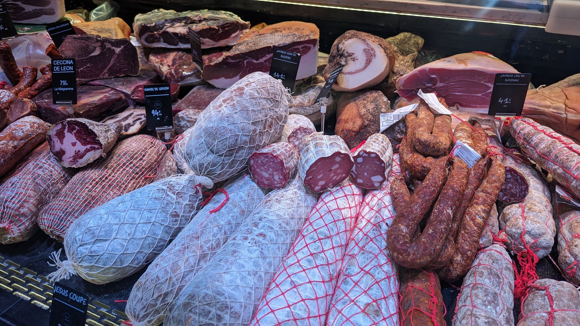 Display of various cured meats, including salami, prosciutto, and sausage.