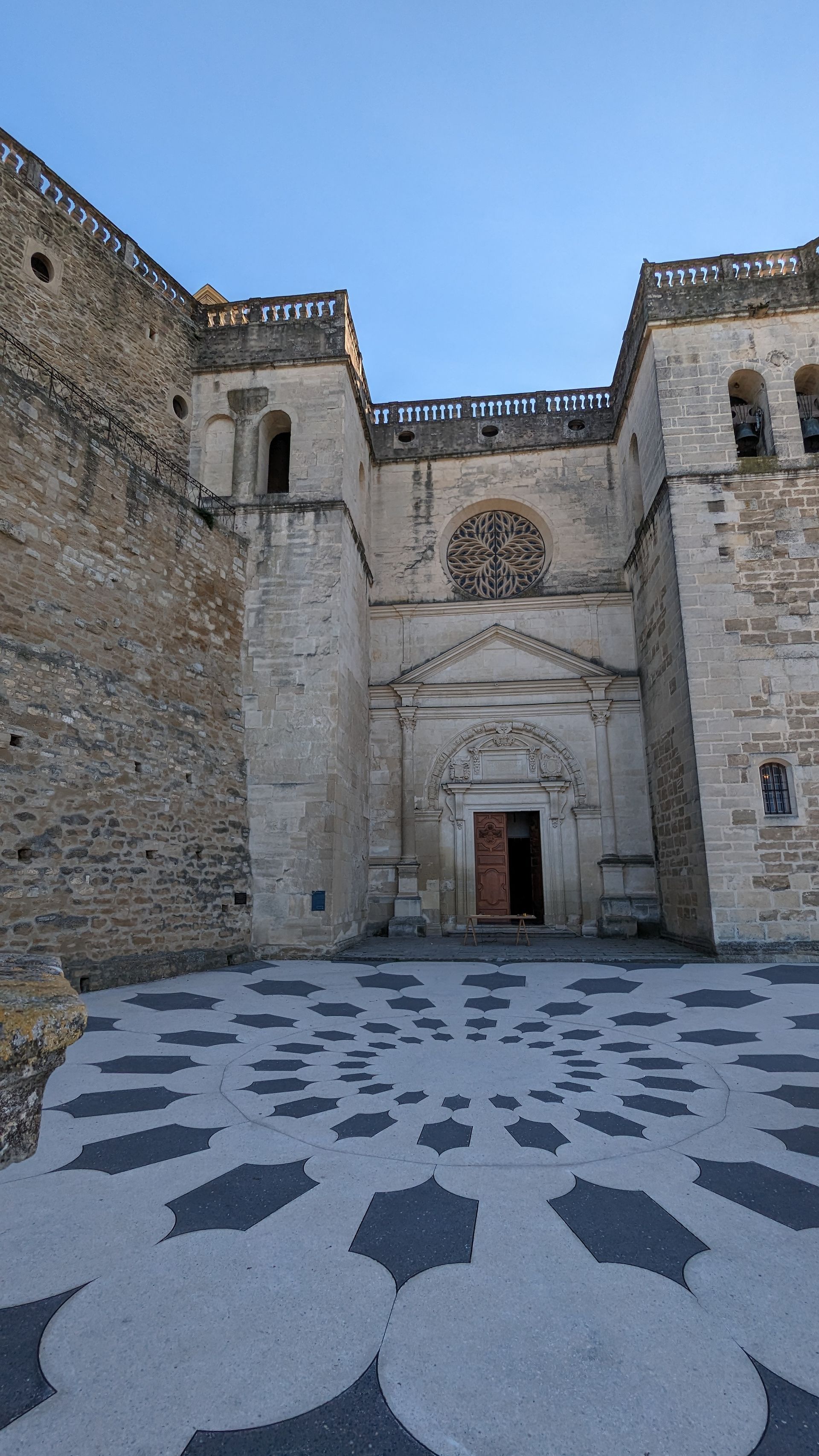 Stone cathedral exterior with ornate tile design in front.