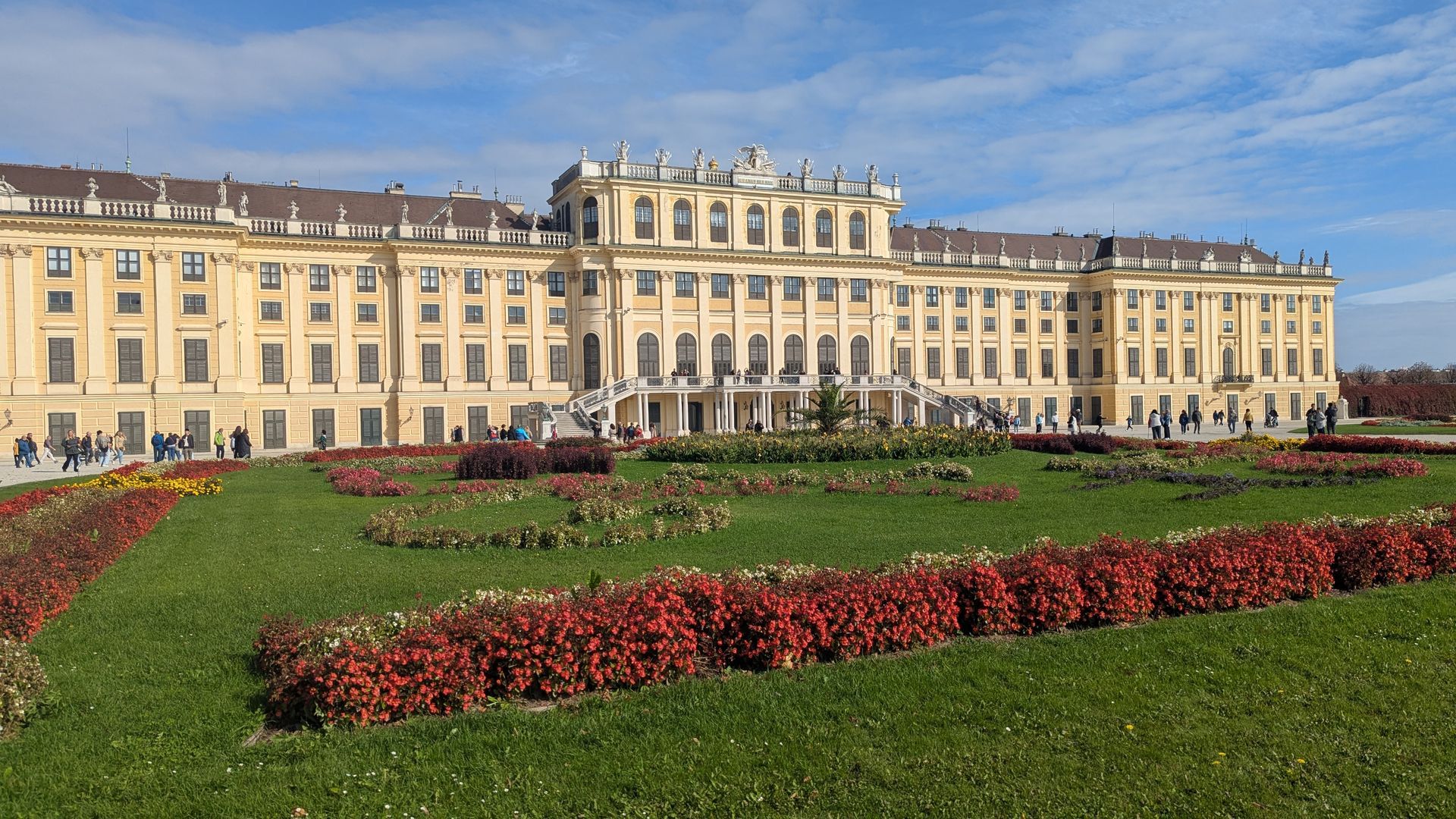 Schönbrunn Palace, Vienna, Austria, with a manicured garden and clear blue sky.