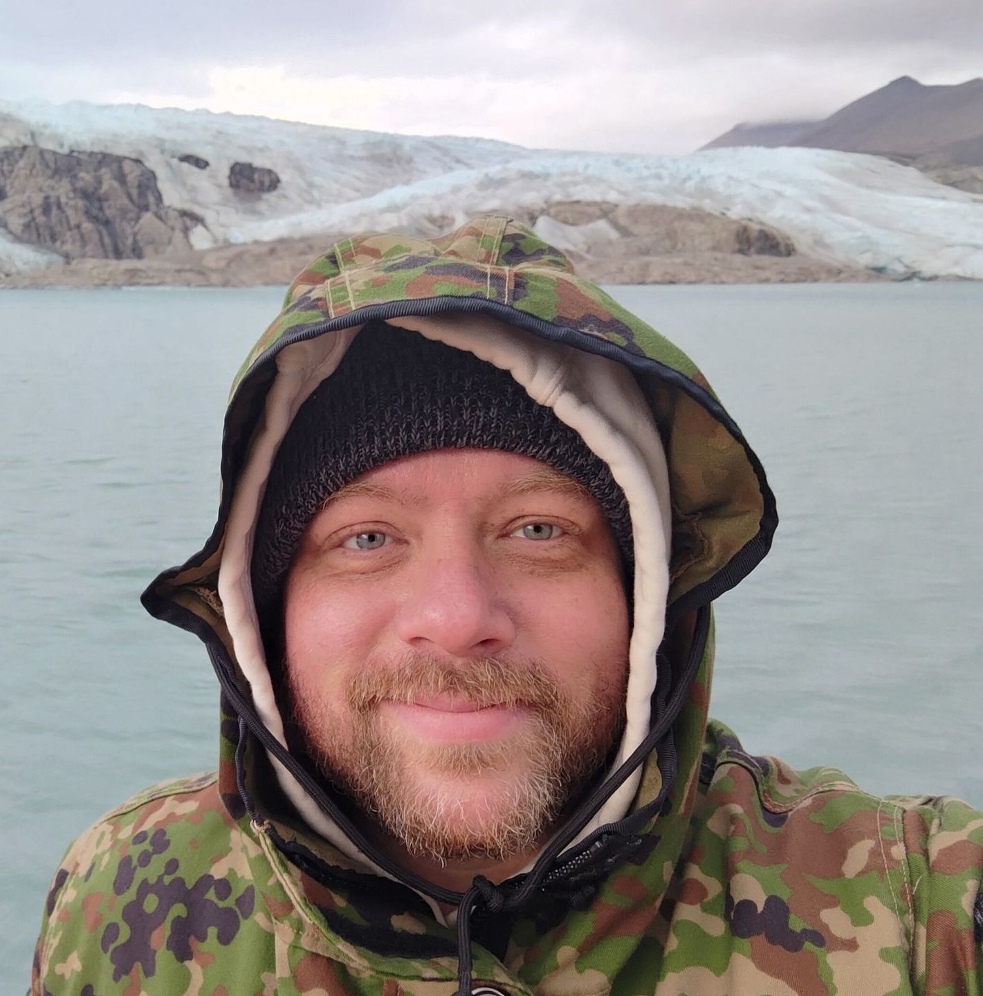 A man with a beard wearing a hooded jacket