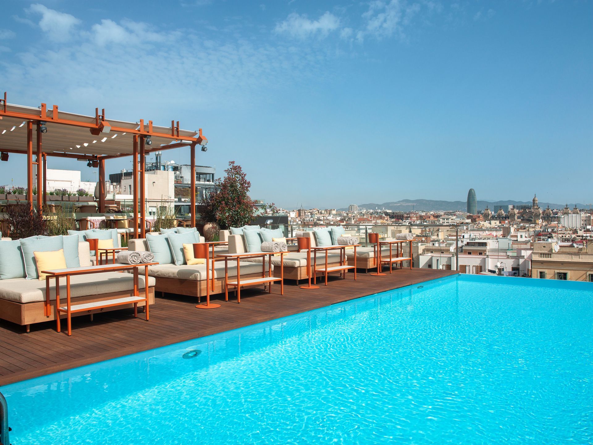 A large swimming pool with a view of a city at Grand Hotel Central in Barcelona, Spain.