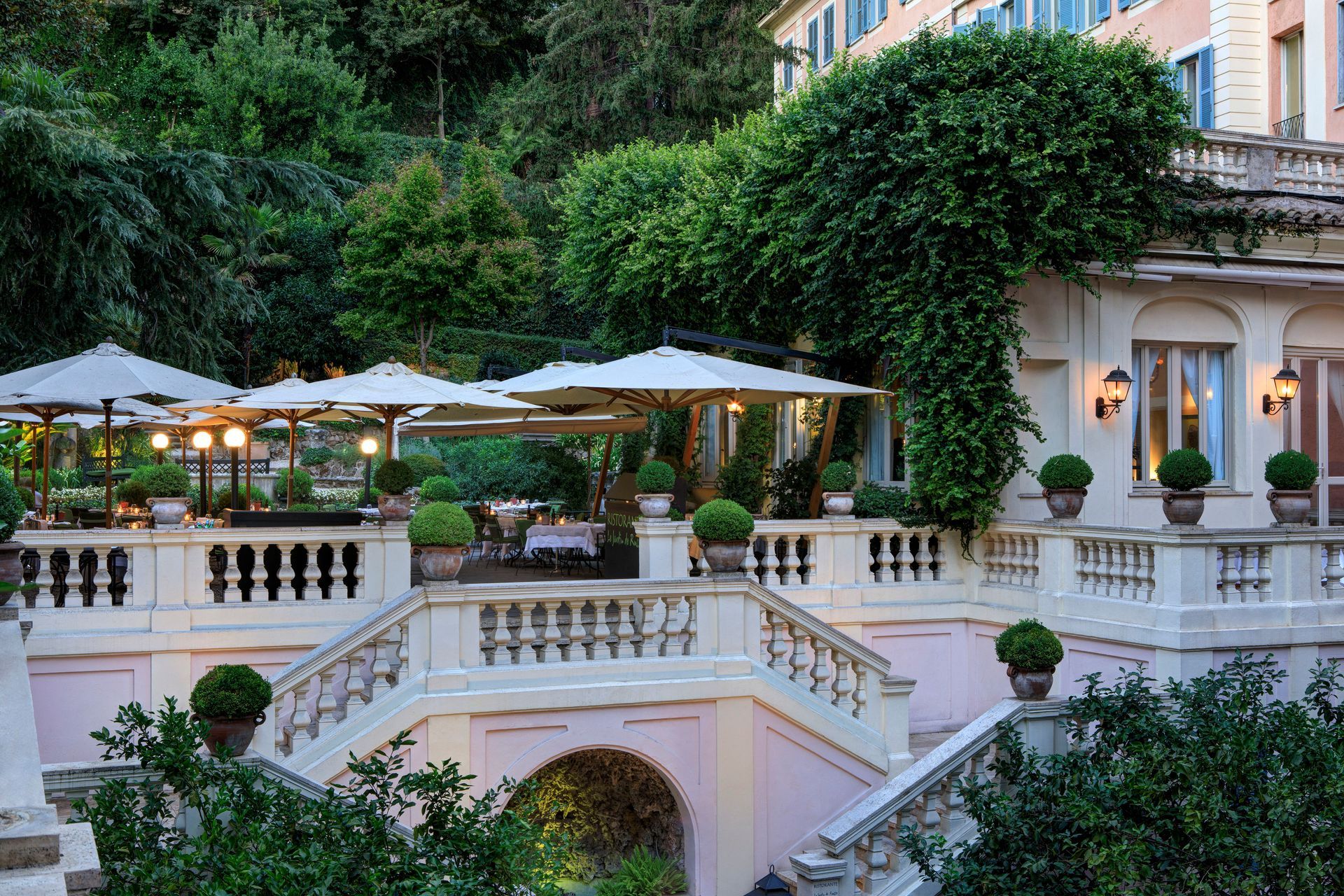 A large building with stairs and umbrellas in front of it in Rome, Italy at Rocco Forte Hotel.