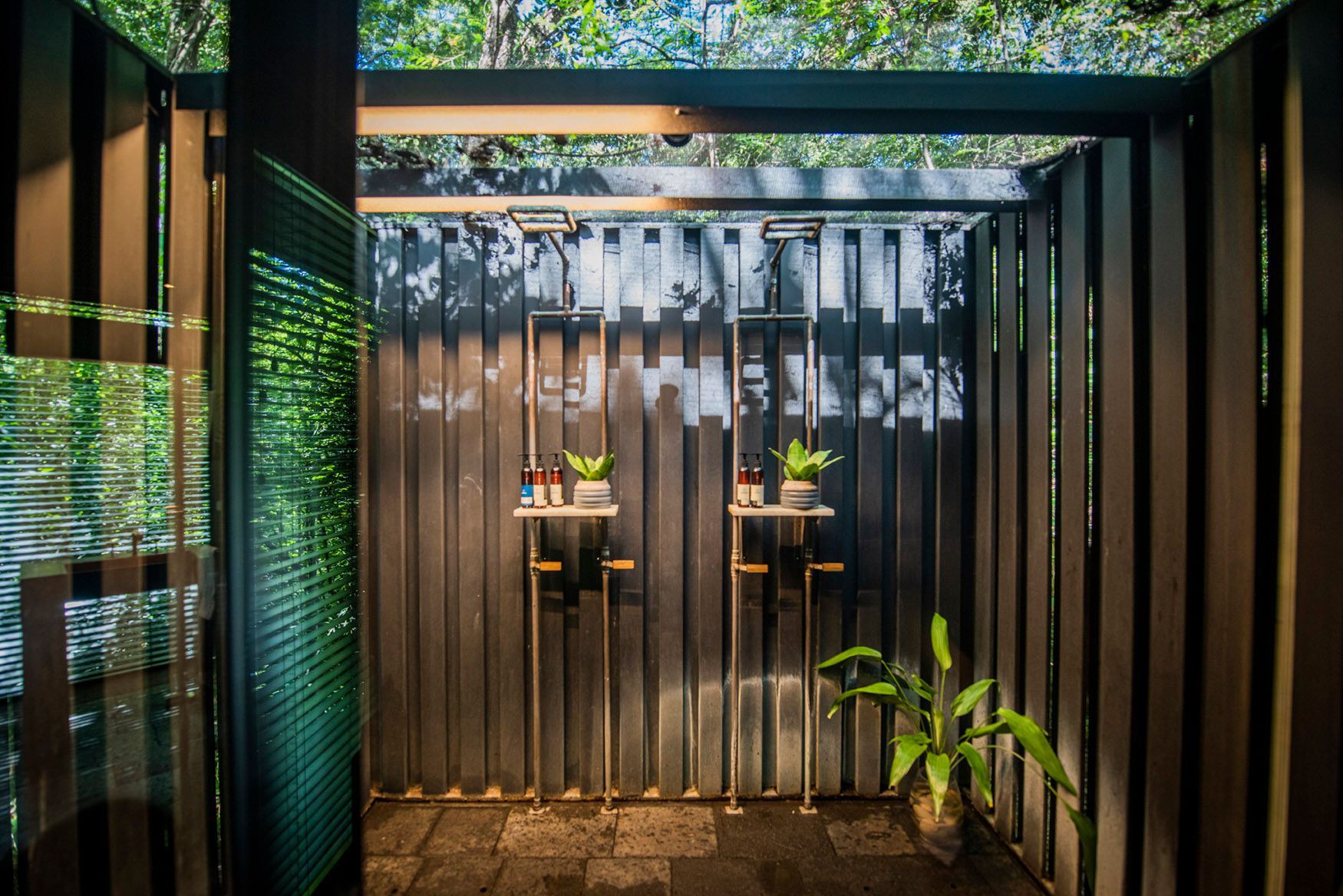 A room with a fence and two shelves with plants on them at at a tree house in Costa Rica.