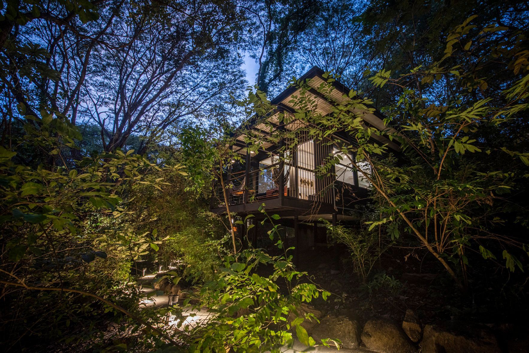 A tree house in the middle of a jungle at night in Costa Rica.