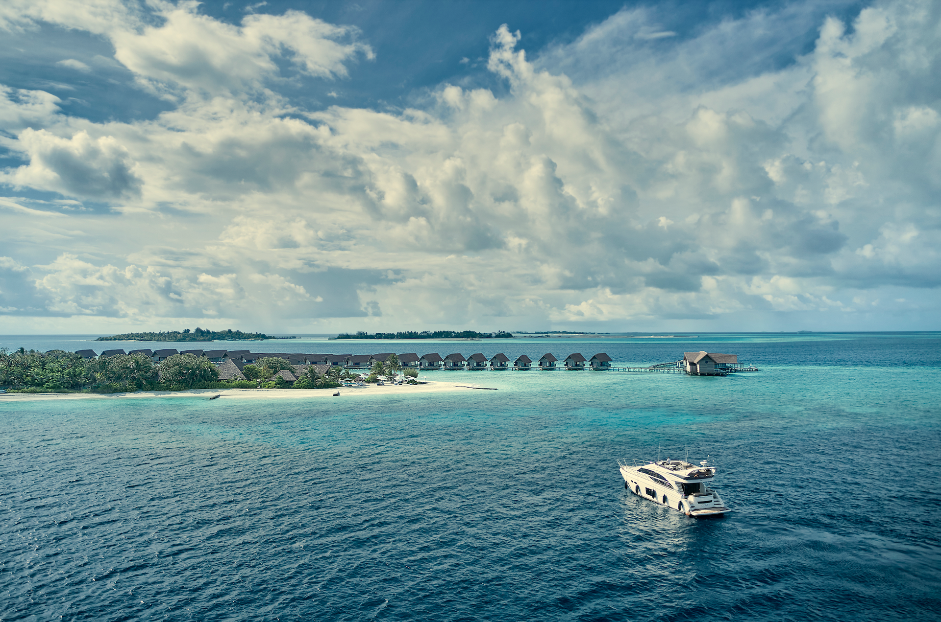 A boat is floating in the ocean near  Como's over the water Bungalow's in the Maldives 