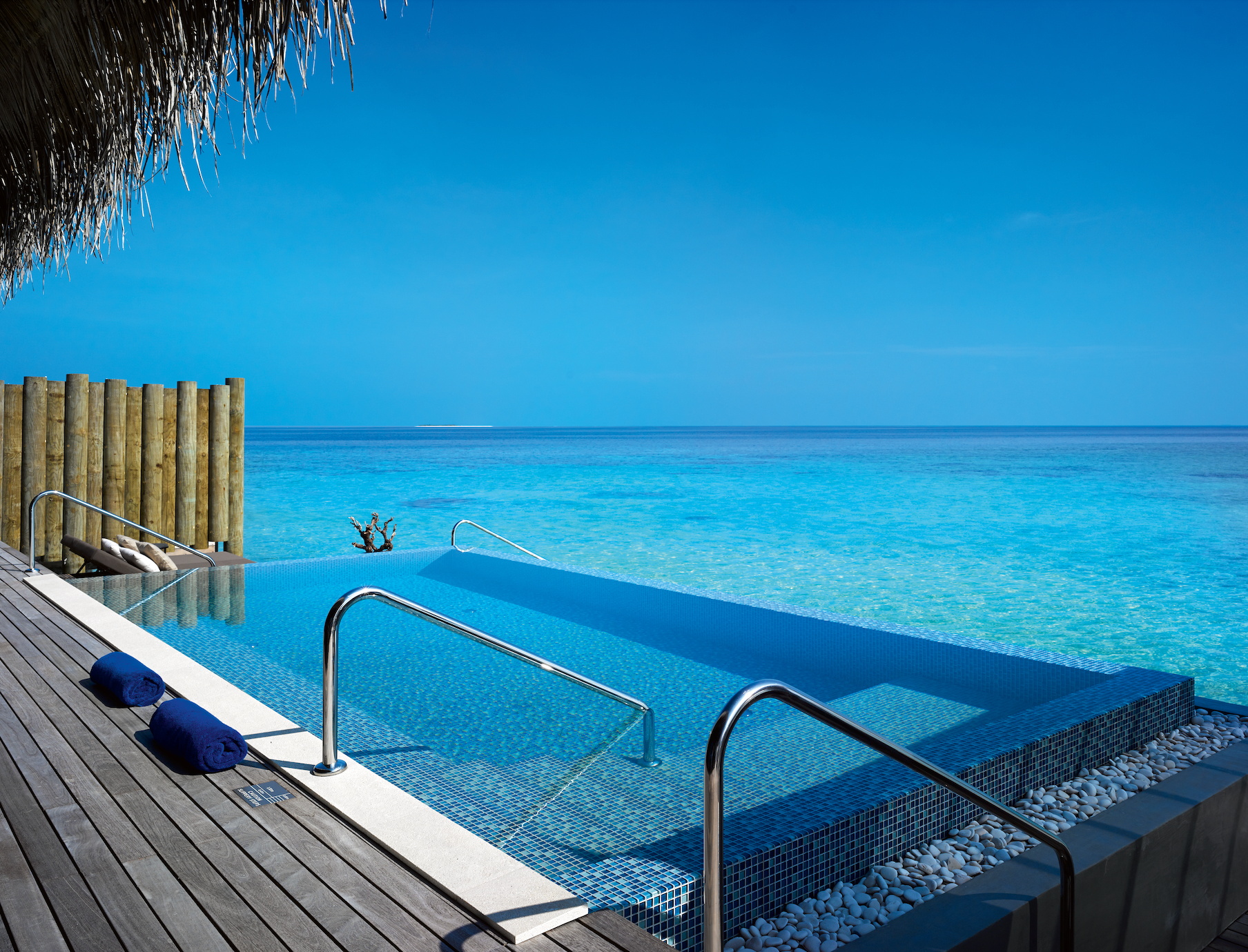 A swimming pool with stairs leading to the Maldives at Velaa's overwater bungalow in the resort. 