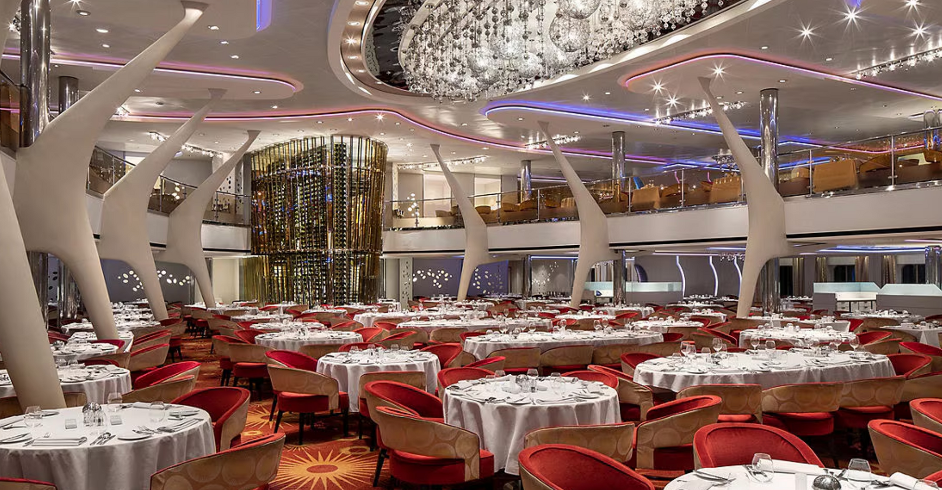 A large dining room filled with tables and chairs and a chandelier on the Celebrity Reflection cruise ship.