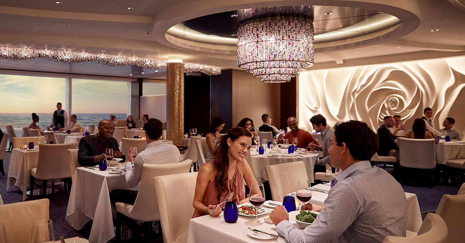 A man and a woman are sitting at a table in a restaurant on the Celebrity Solstice cruise ship.