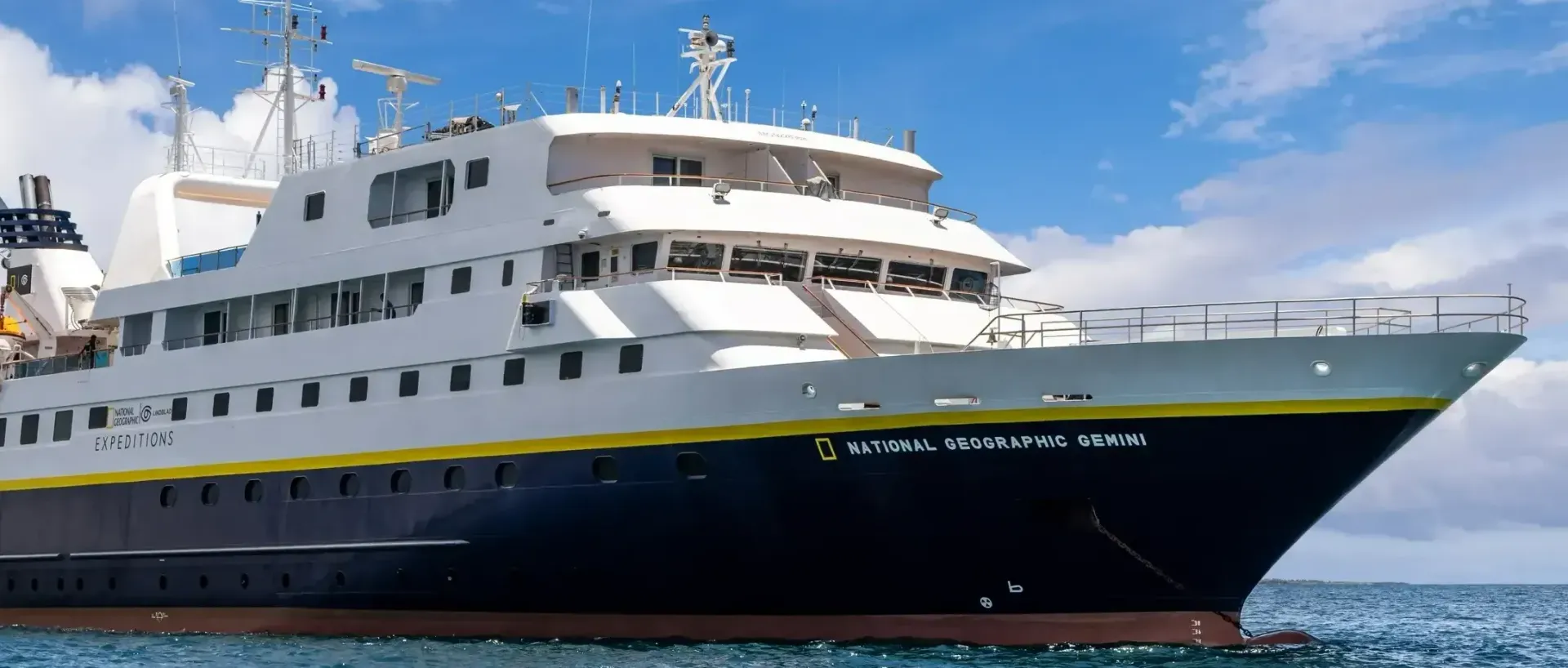 Lindblad's Gemini Expedition Cruise ship is floating on top of a body of water.