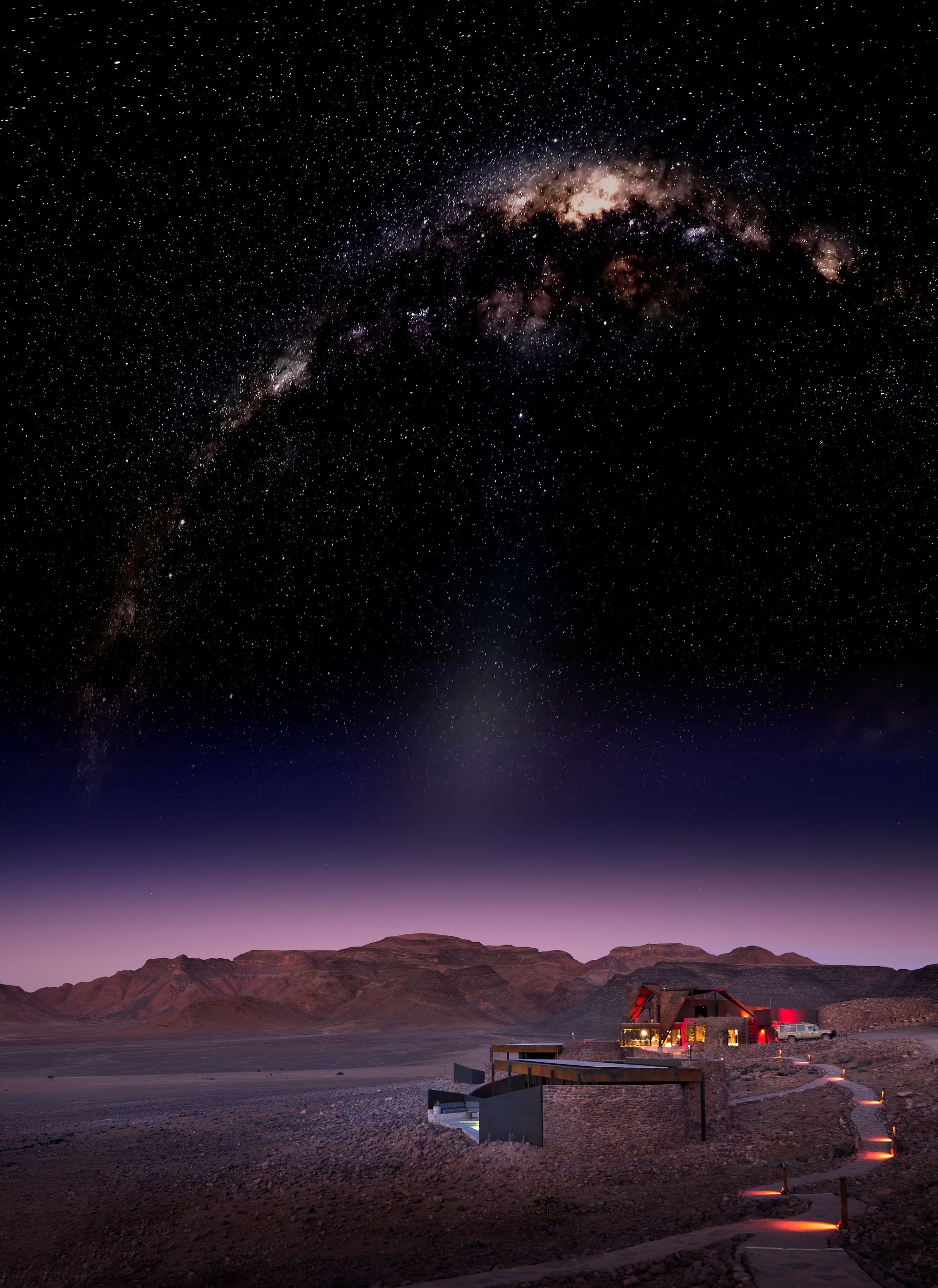 A night sky with a lot of stars and a building in the foreground at a desert camp in Africa.