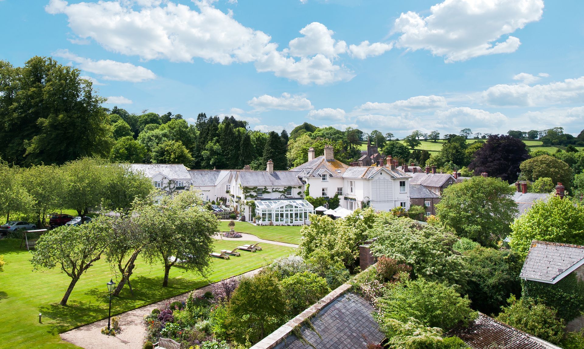 An aerial view of a house surrounded by trees and grass at the Dorset, Uk Red Carnation Hotel. 