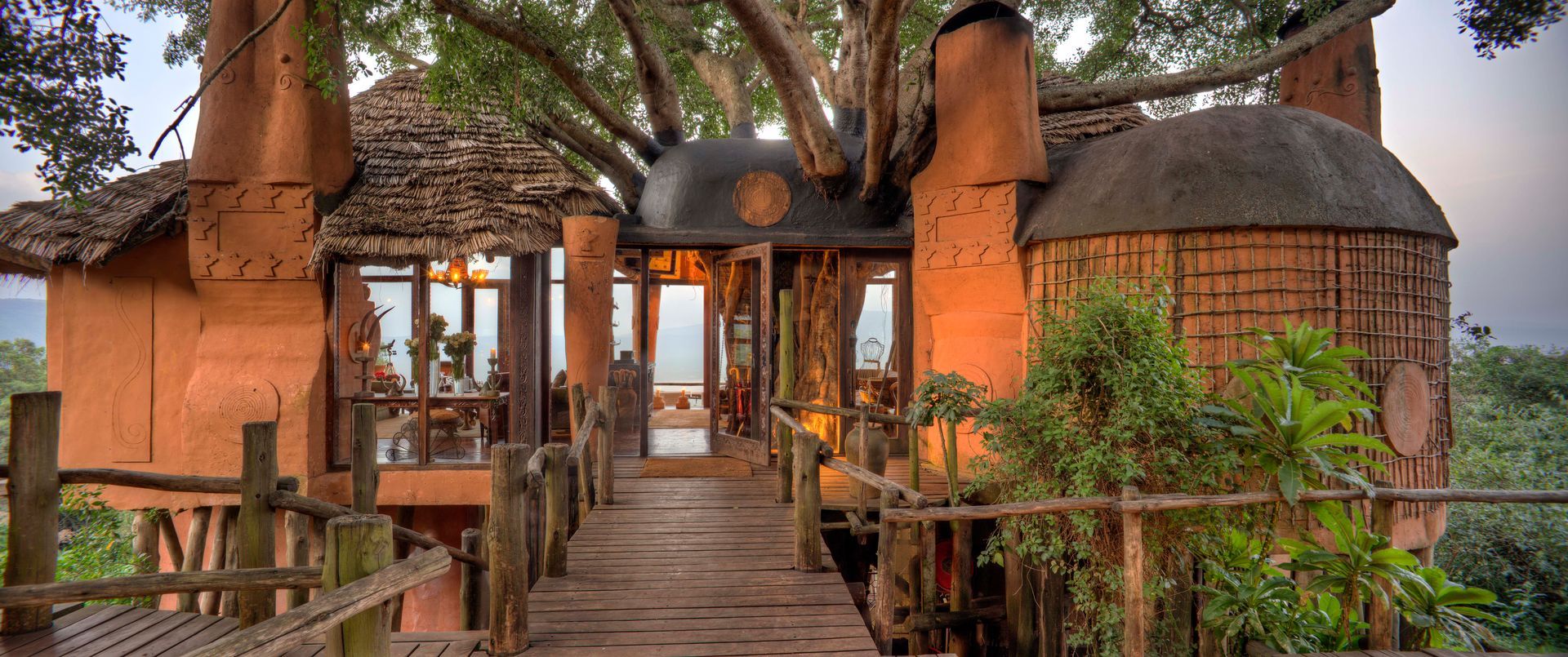 A tree house with a wooden walkway leading to it in Africa.