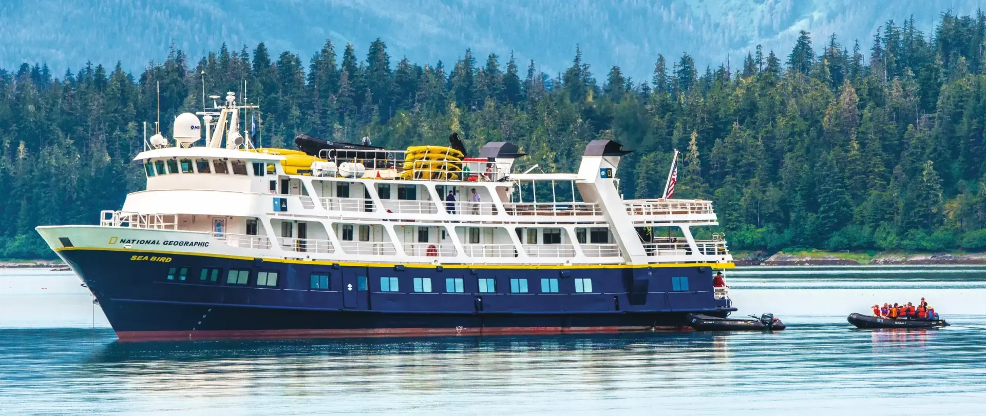 Lindblad's Sea Bird Expedition Cruise Ship is floating on top of a body of water.