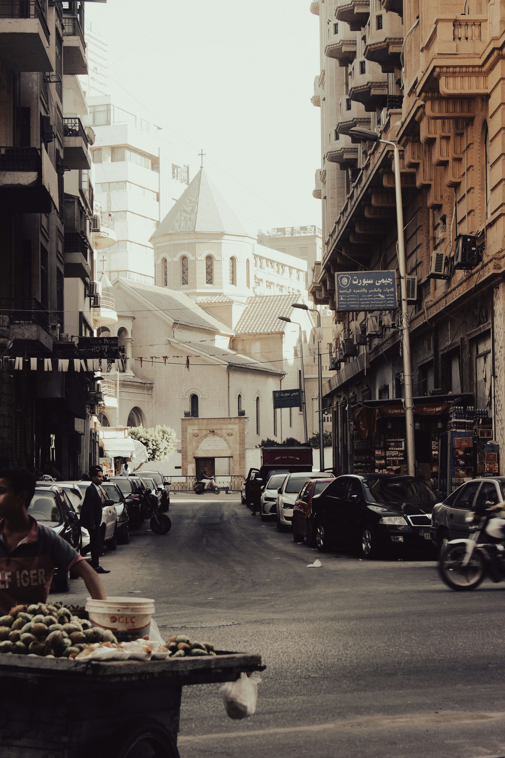 A busy city street with a sign that says ' cafe ' on it in Cairo, Egypt.