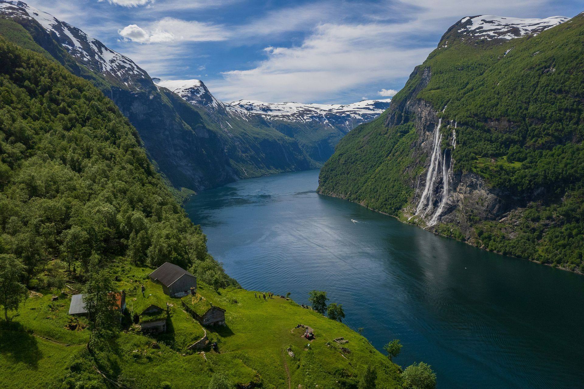 An aerial view of a fjord surrounded by mountains and trees in Norway.