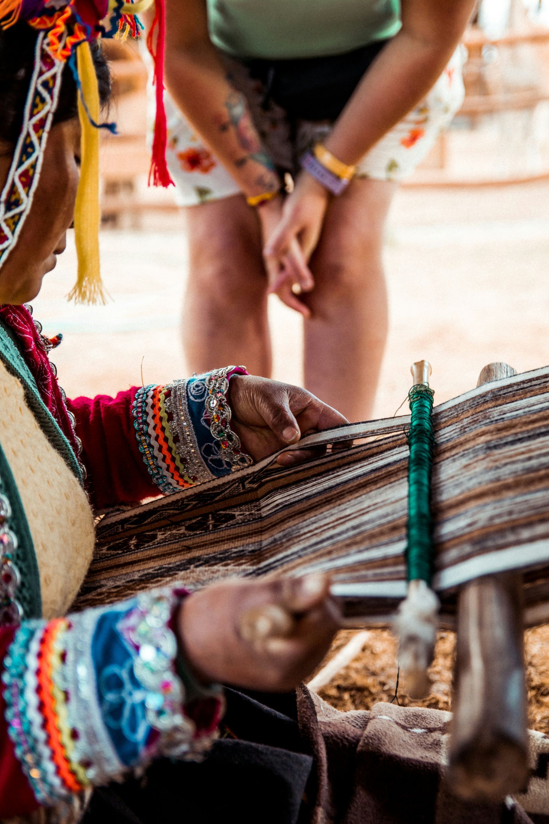 A woman is weaving a piece of fabric on a loom in Peru.