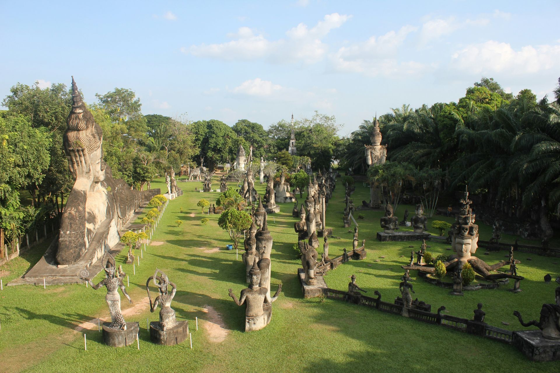 Park with numerous stone sculptures and monuments. Green grass, trees in Vientiane, Laos.