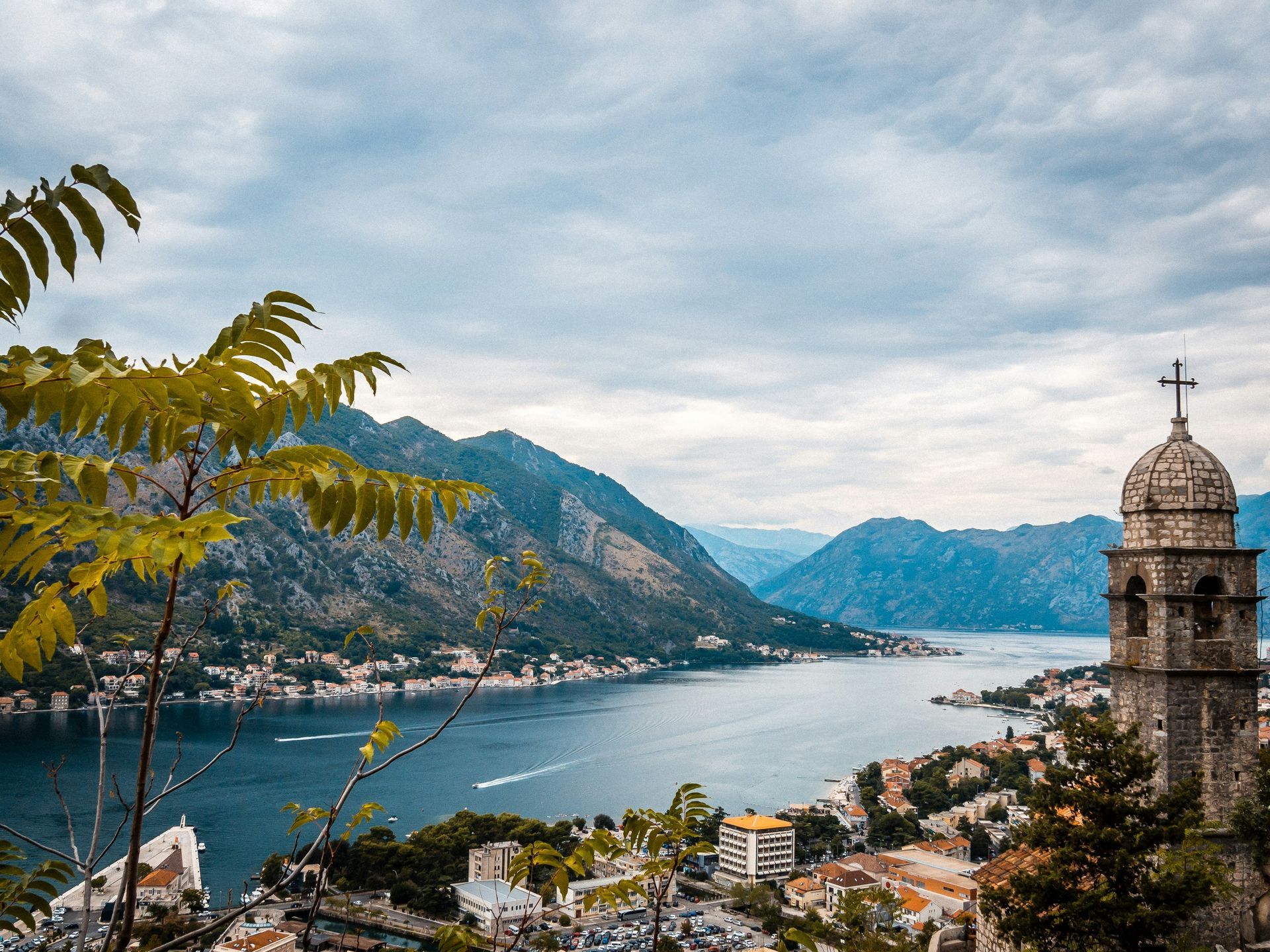 A view of a city and a lake with mountains in the background in Montenegro.