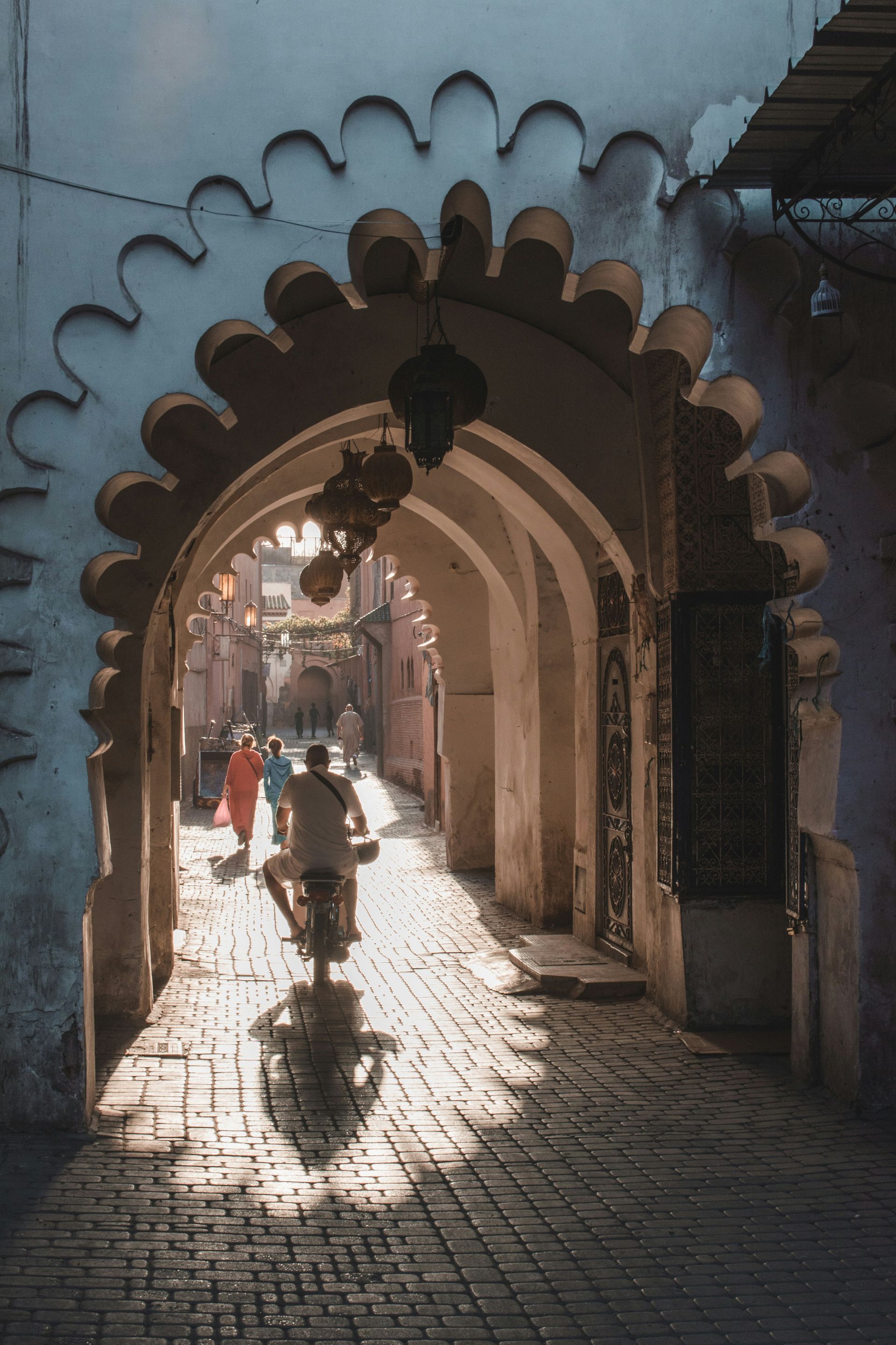 A man is riding a bicycle through an archway in Marrakesh, Morocco.