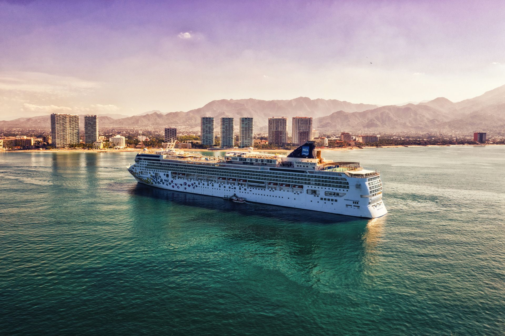 A large cruise ship is floating on top of a body of water.