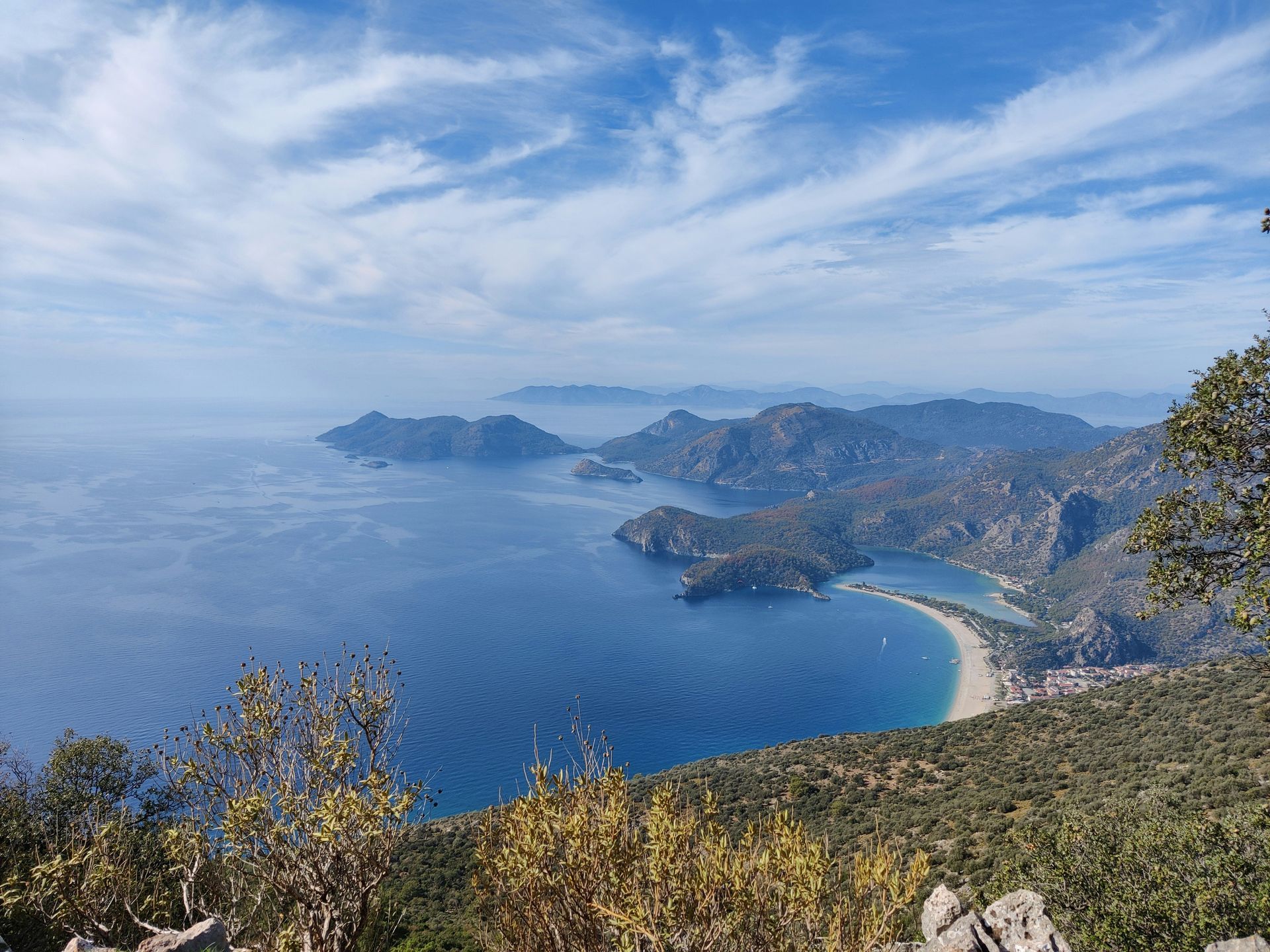 Coastal view with blue sea, mountains, and a sandy beach in Fethiye, Turkey.