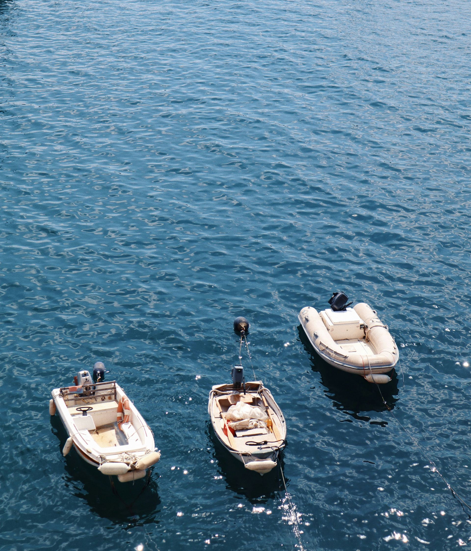 Three boats are floating on top of a body of water on the French Riviera.