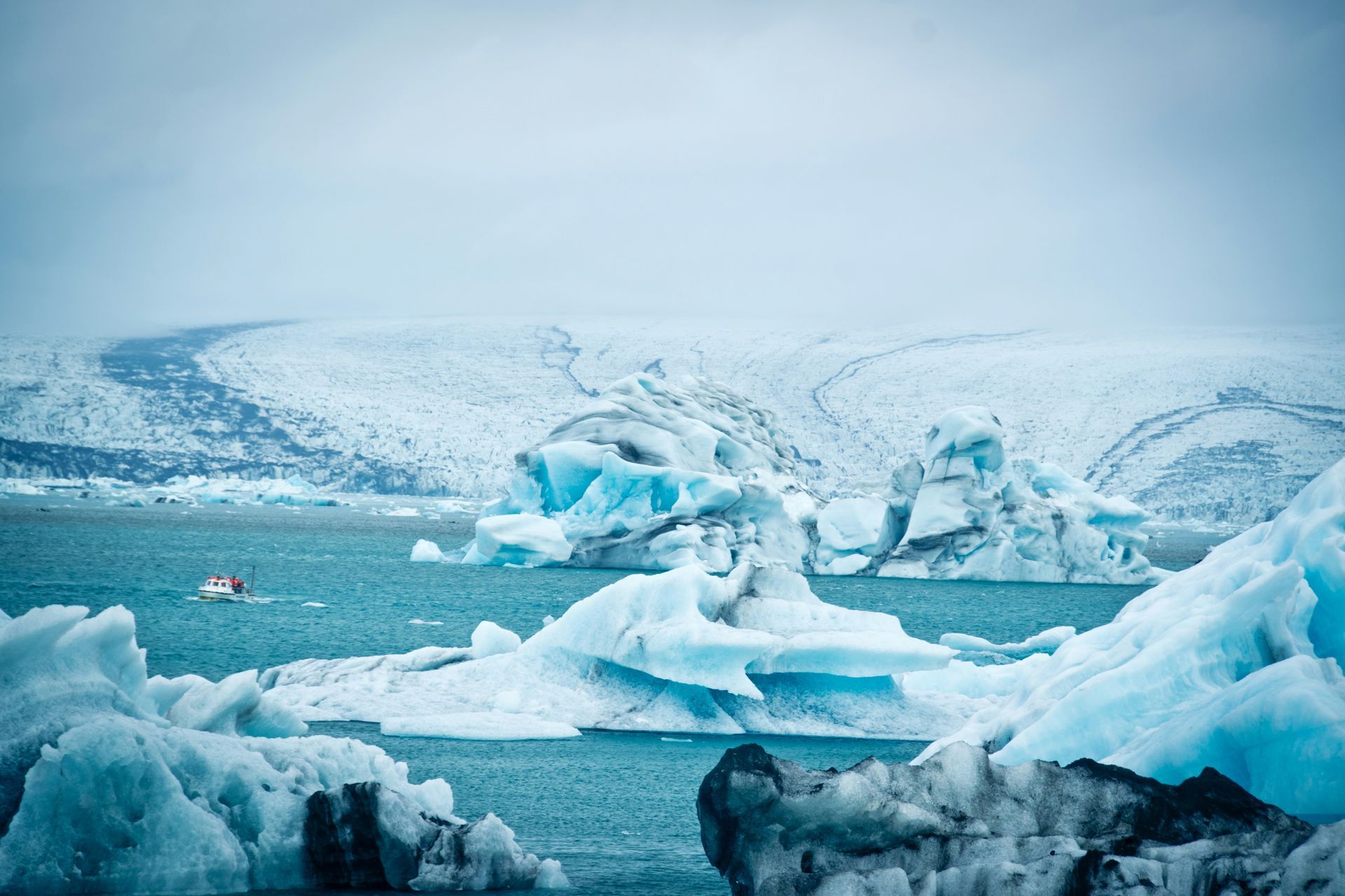 Icebergs floating in Jökulsárlón Glacier Lagoon with a glacier in the background in Iceland.