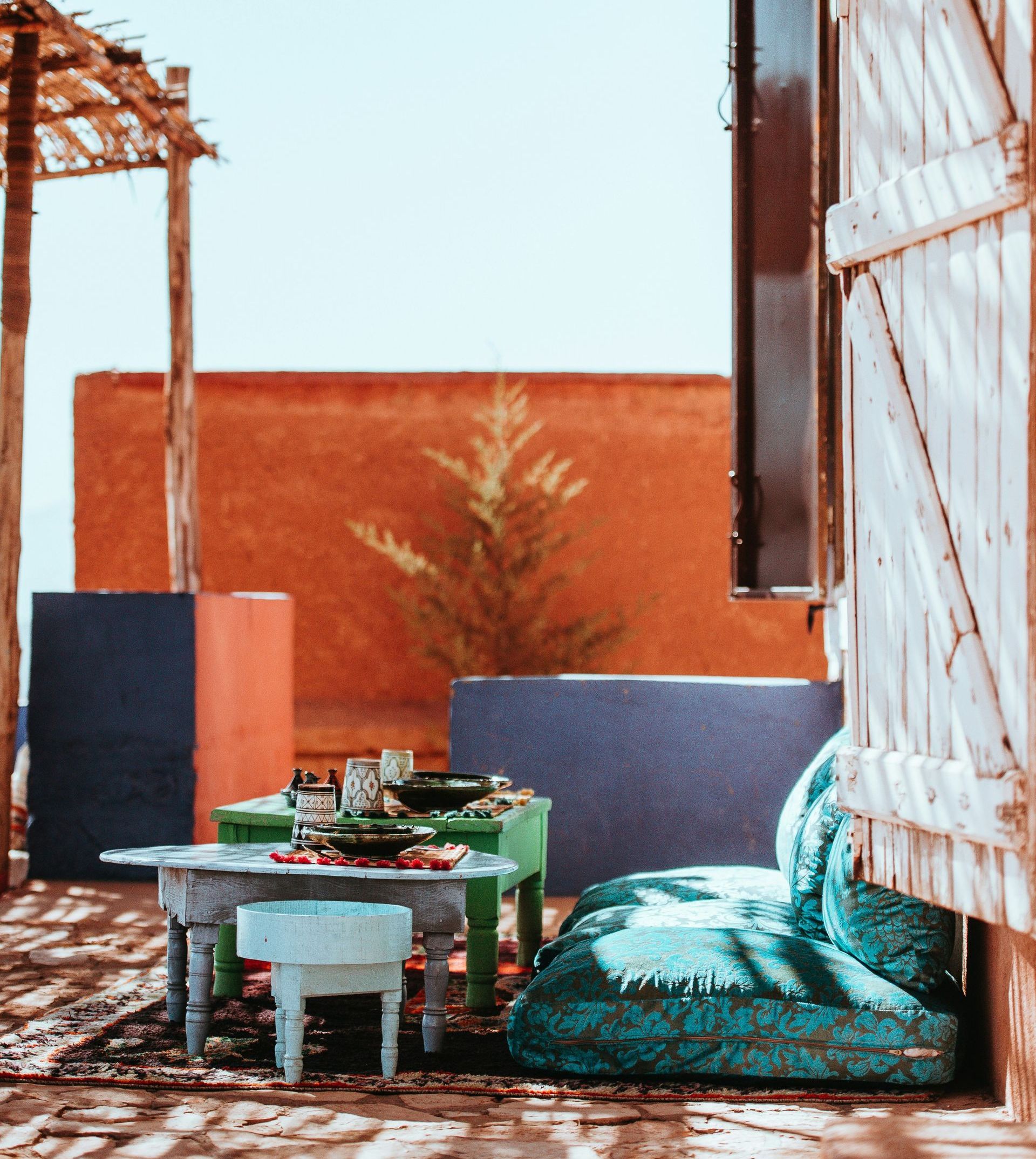 A patio with a green table and a blue chair in Morocco.