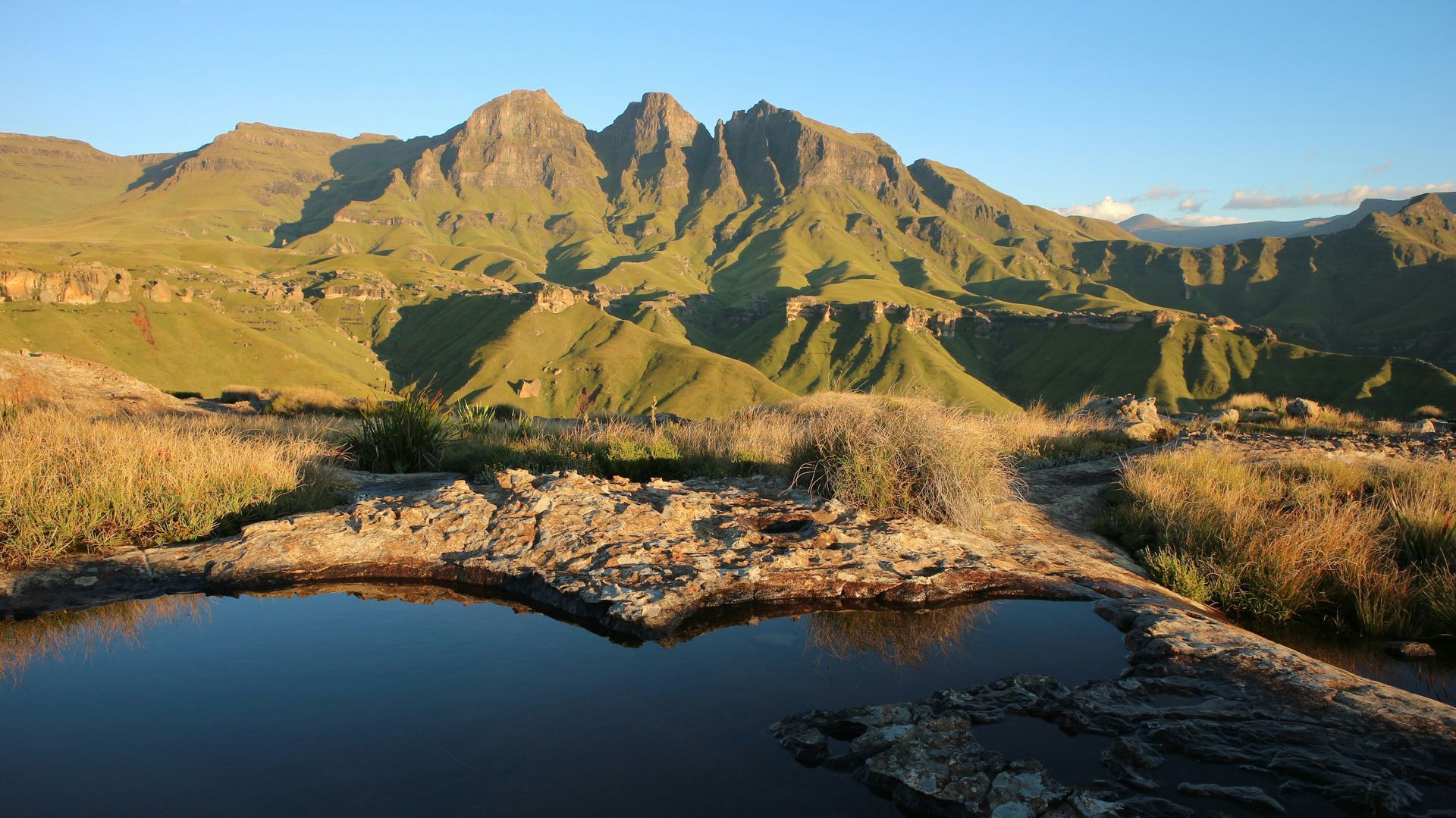 Mountain landscape with still pond reflecting peaks in the Drakensberg, South Africa.