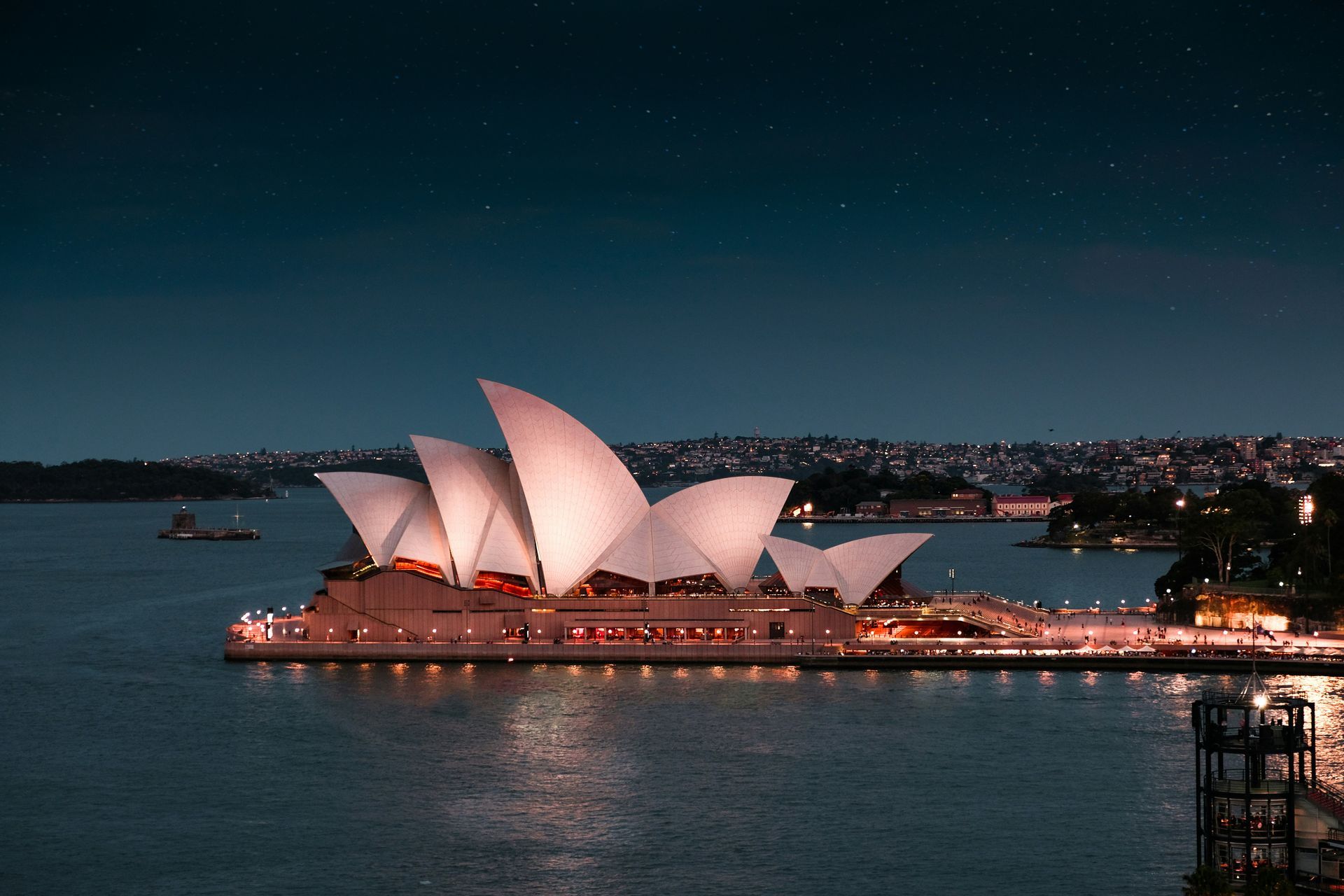 The opera house in Sydney, Australia is lit up at night.
