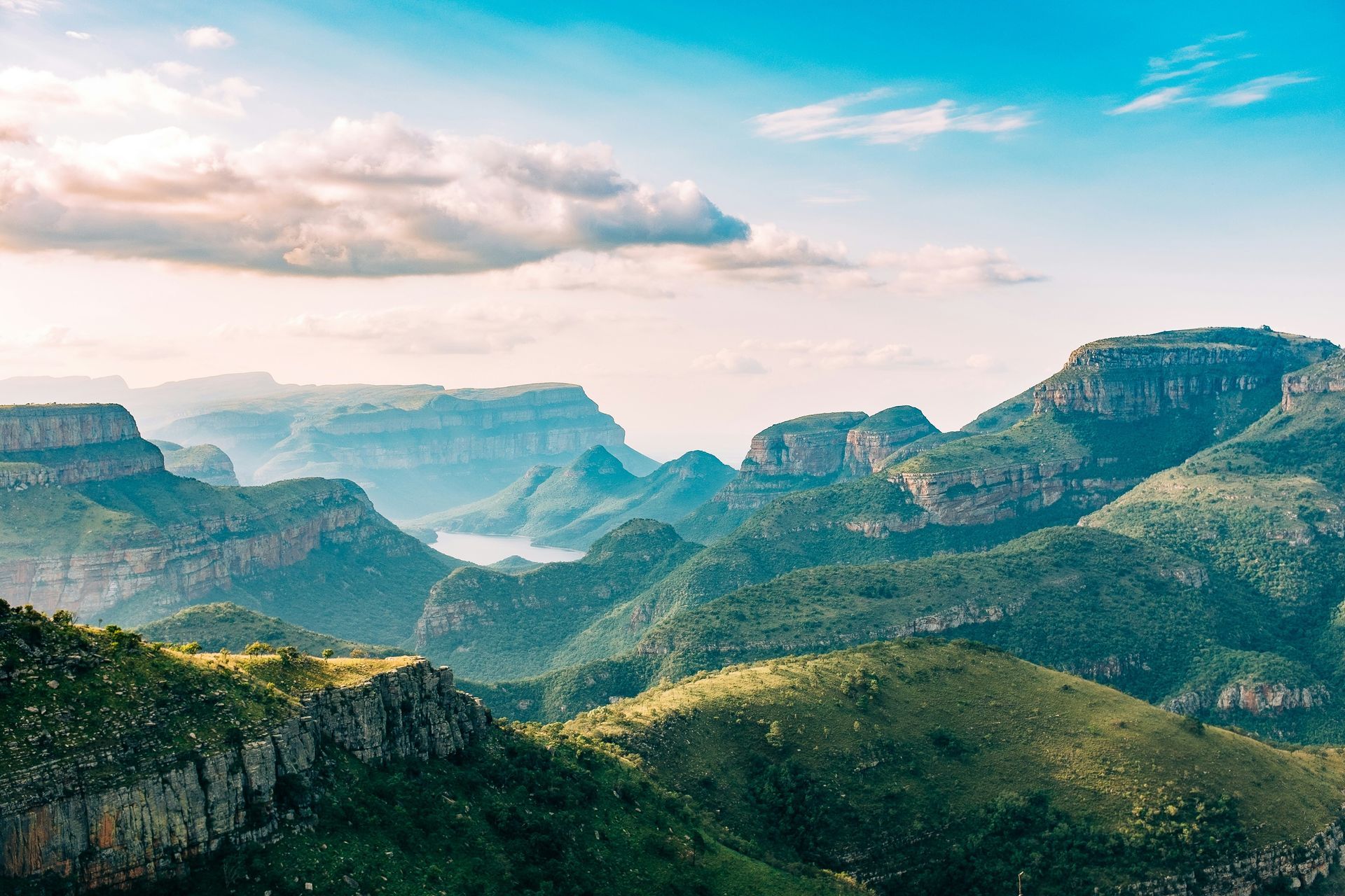 Mountainous landscape of Blyde River Canyon, lush green hills and cliffs dominate the scene in South Africa.
