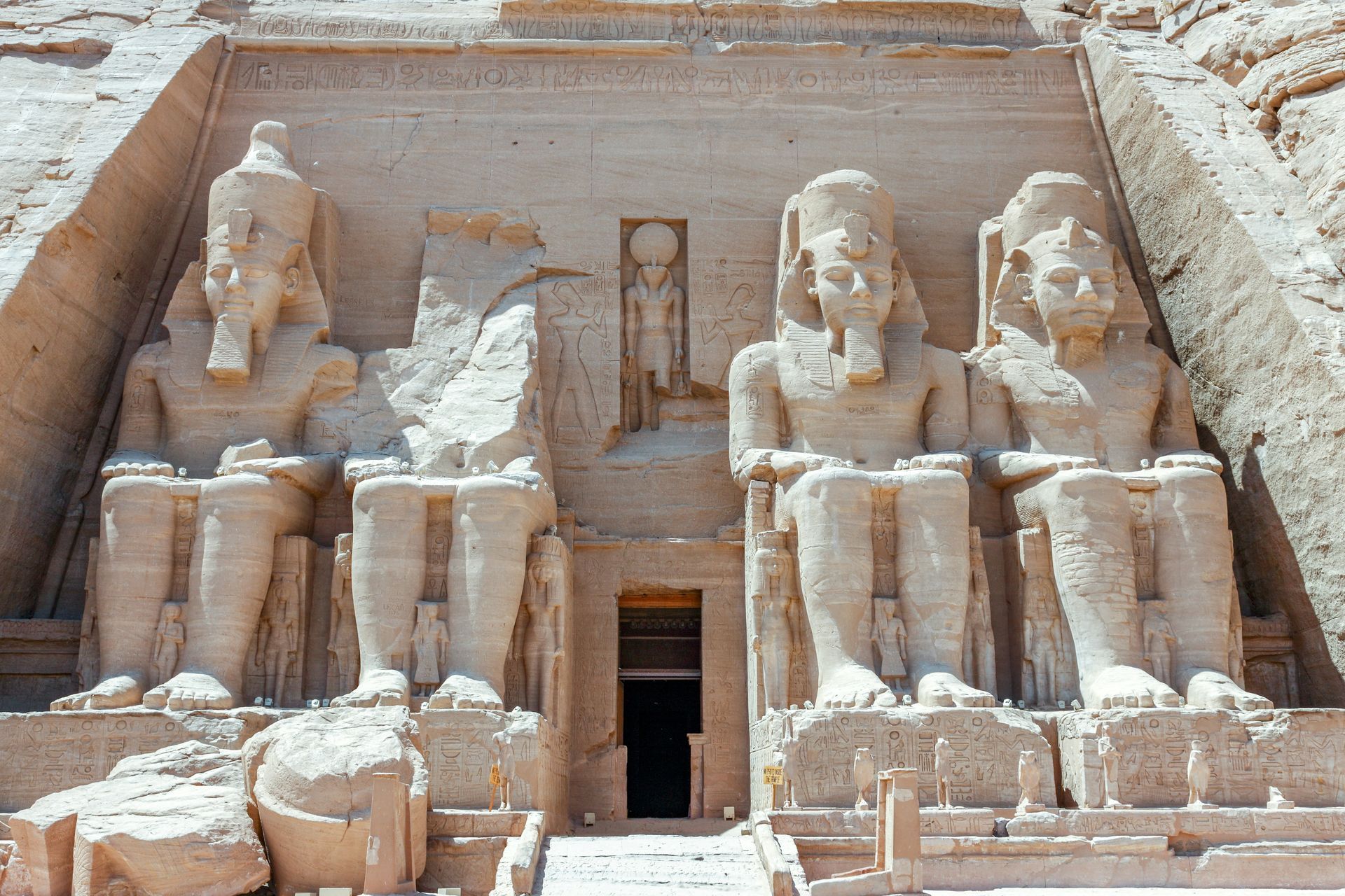 A group of statues are sitting in front of a building in Abu Simbel, Egypt.