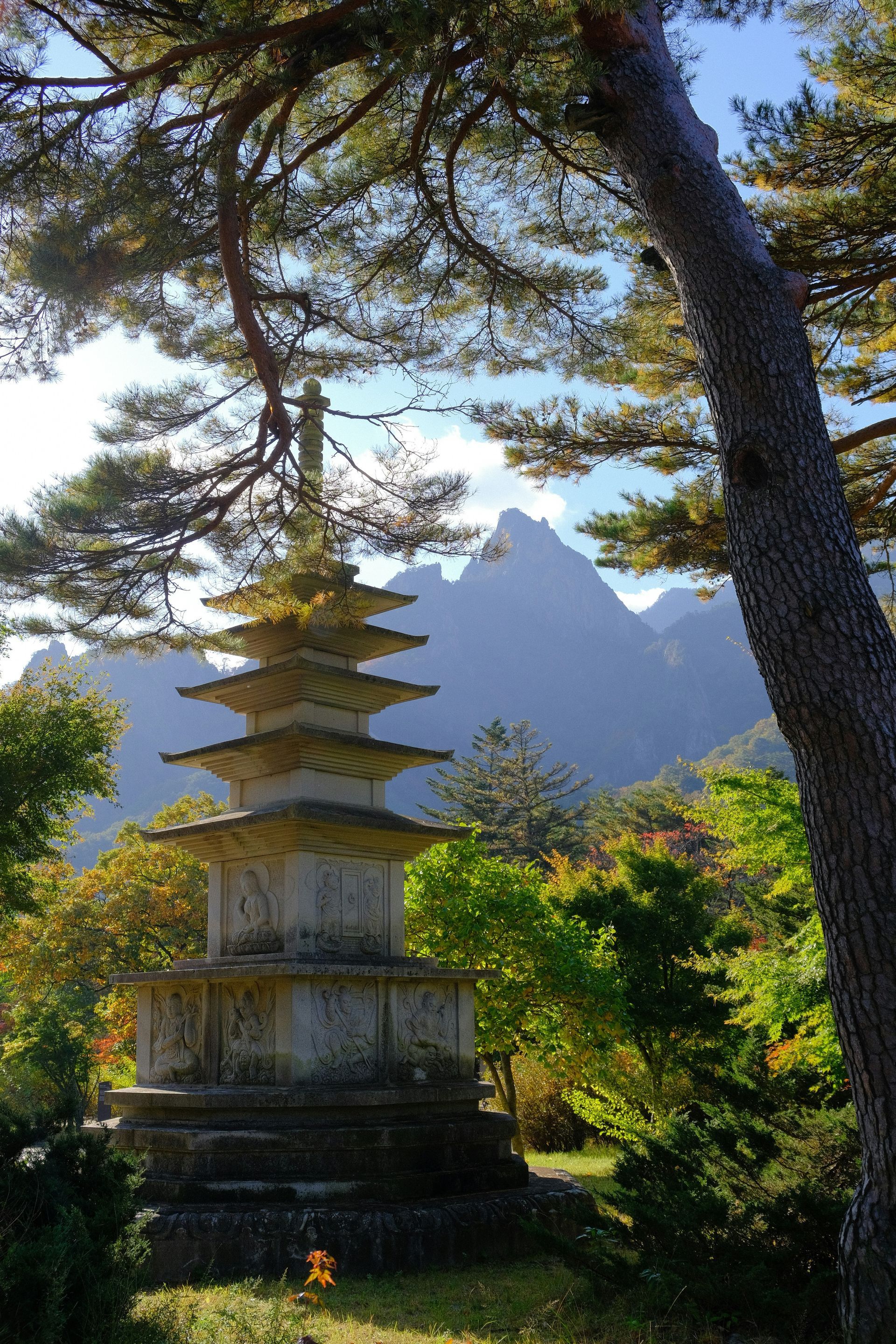 Stone pagoda in a garden, with mountains in the background in Seoraksan National Park, South Korea.