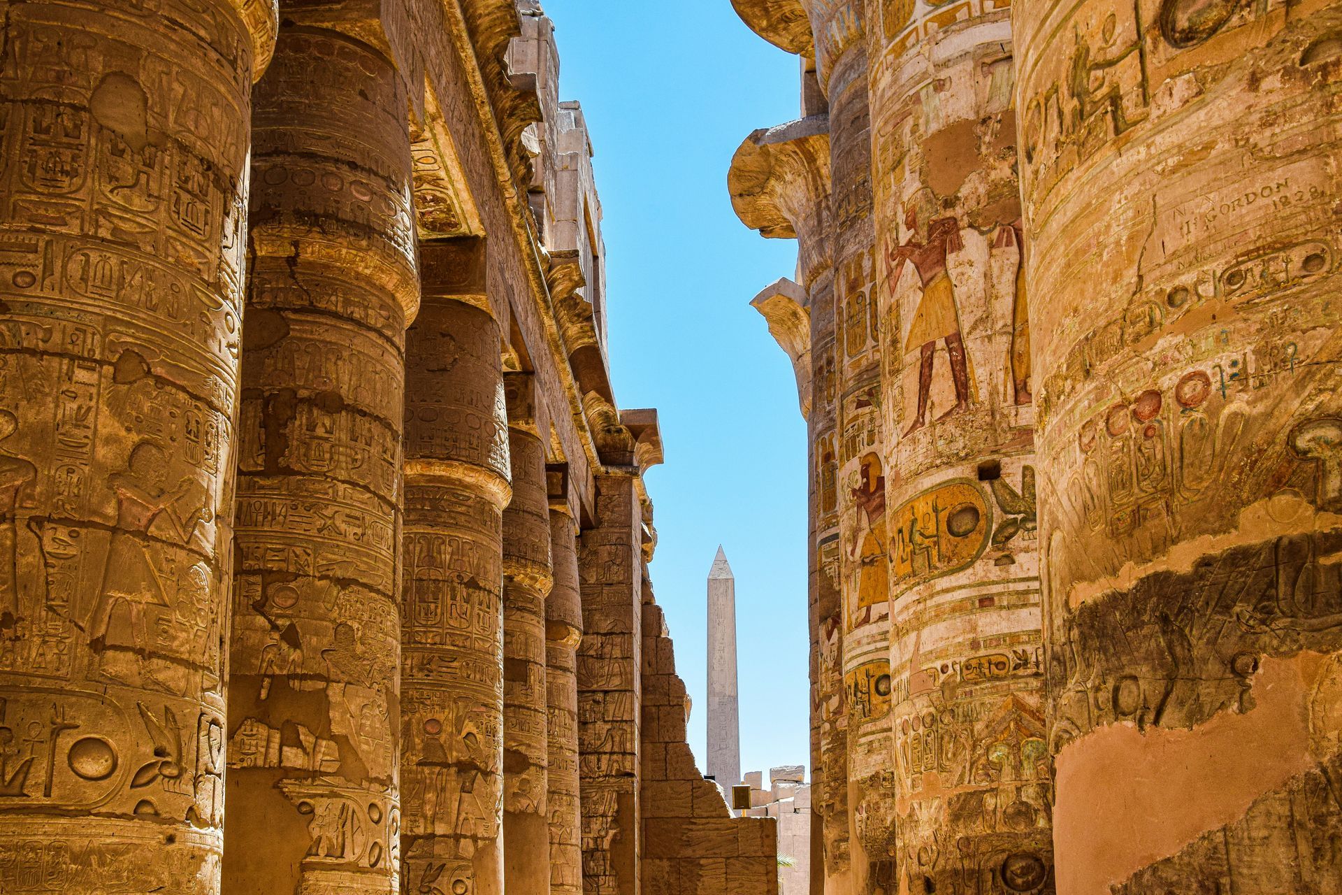 A row of columns in an ancient building with a blue sky in the background in Luxor, Egypt.