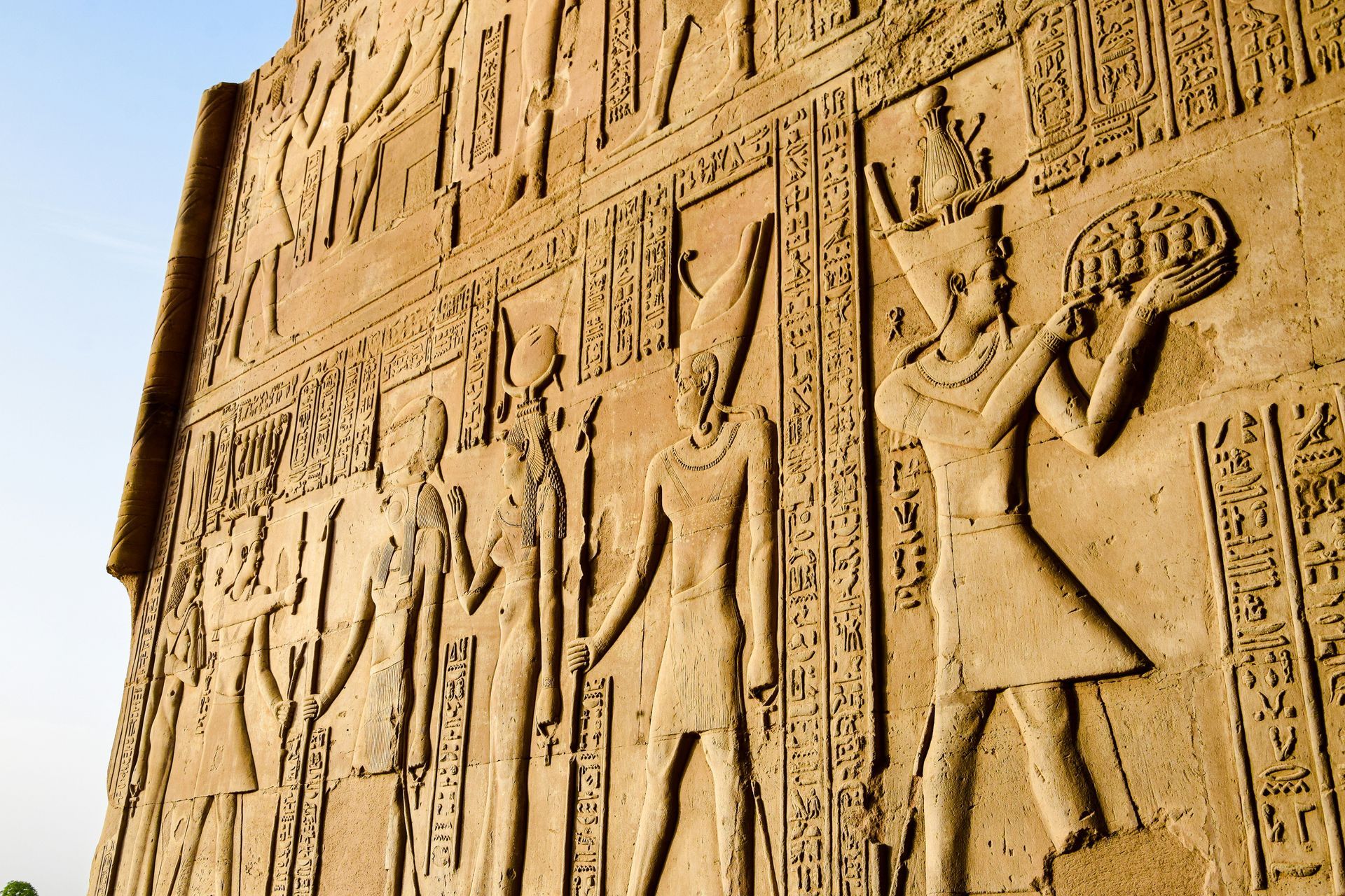 A stone wall with a hieroglyphic of a man playing a flute in Kom Ombo, Egypt.
