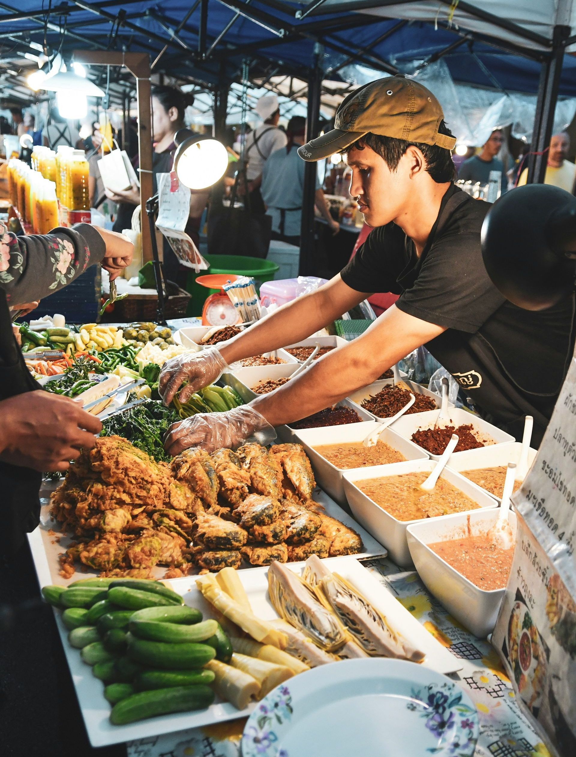 A man is preparing food at a market in Thailand.