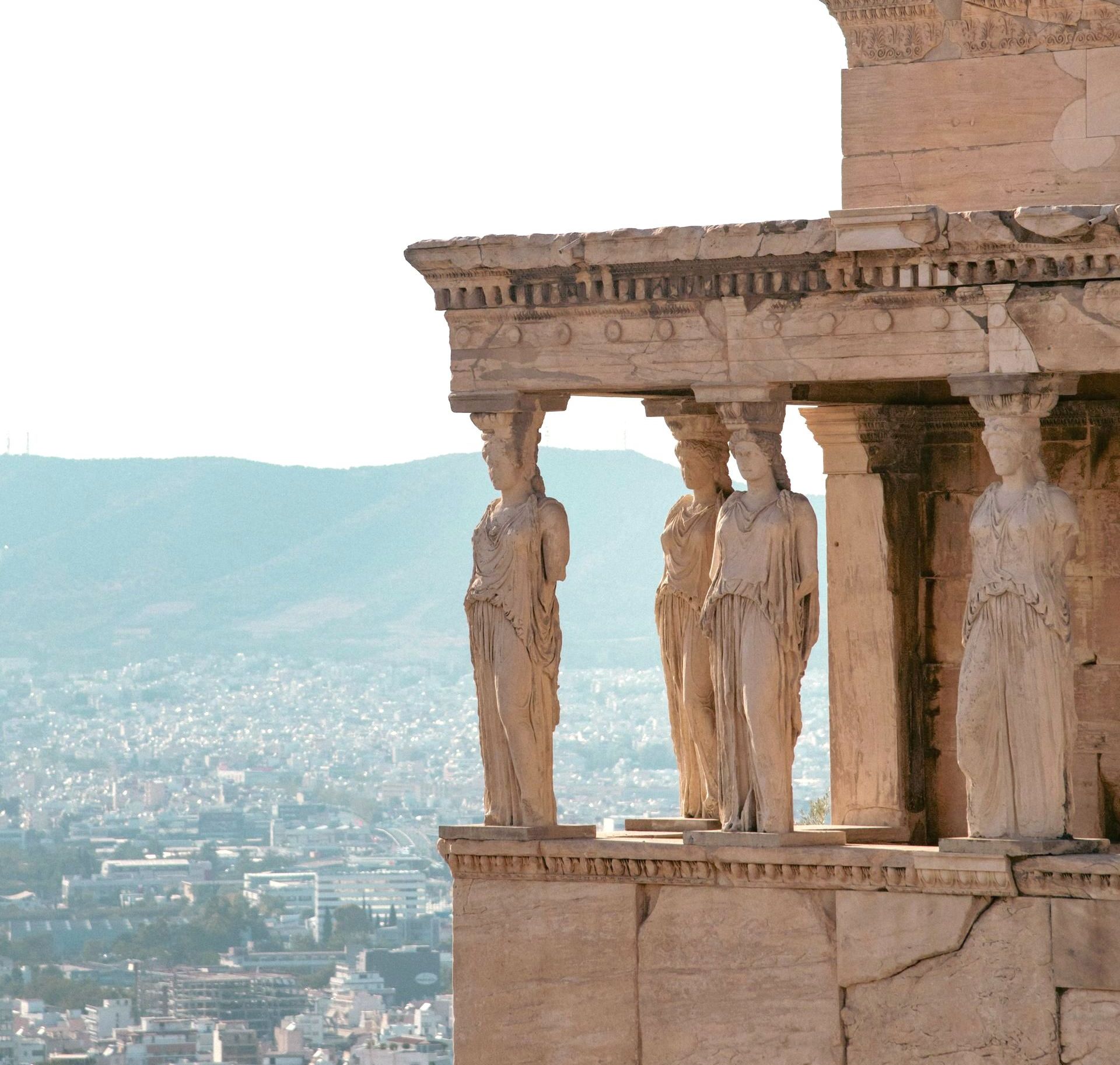 A very old building with statues on top of it, at The Porch of the Caryatids, in Athens, Greece.
