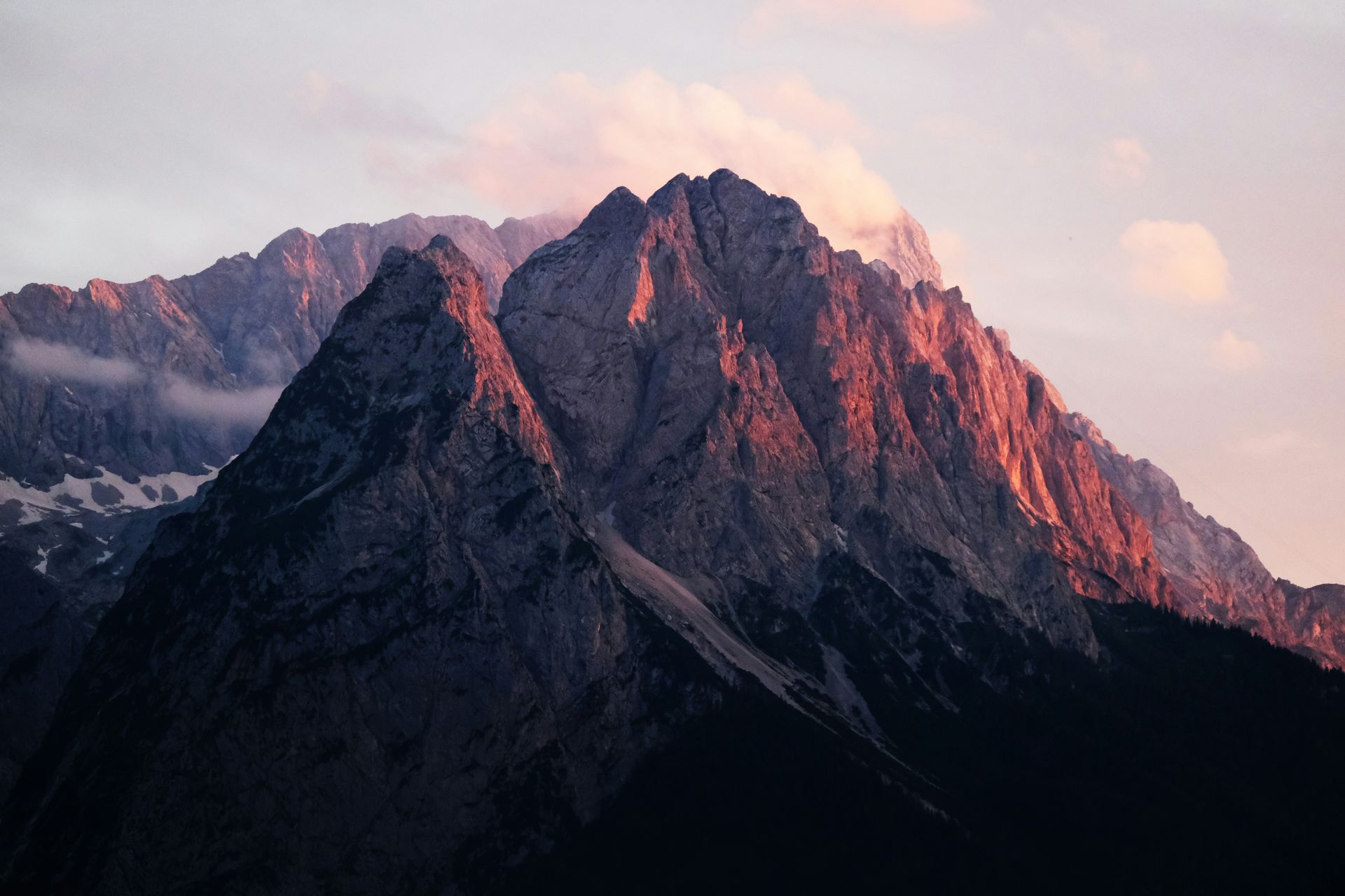 Rugged Zugspitze mountain peaks lit by golden sunlight at dusk in the Bavarian Alps, Germany.