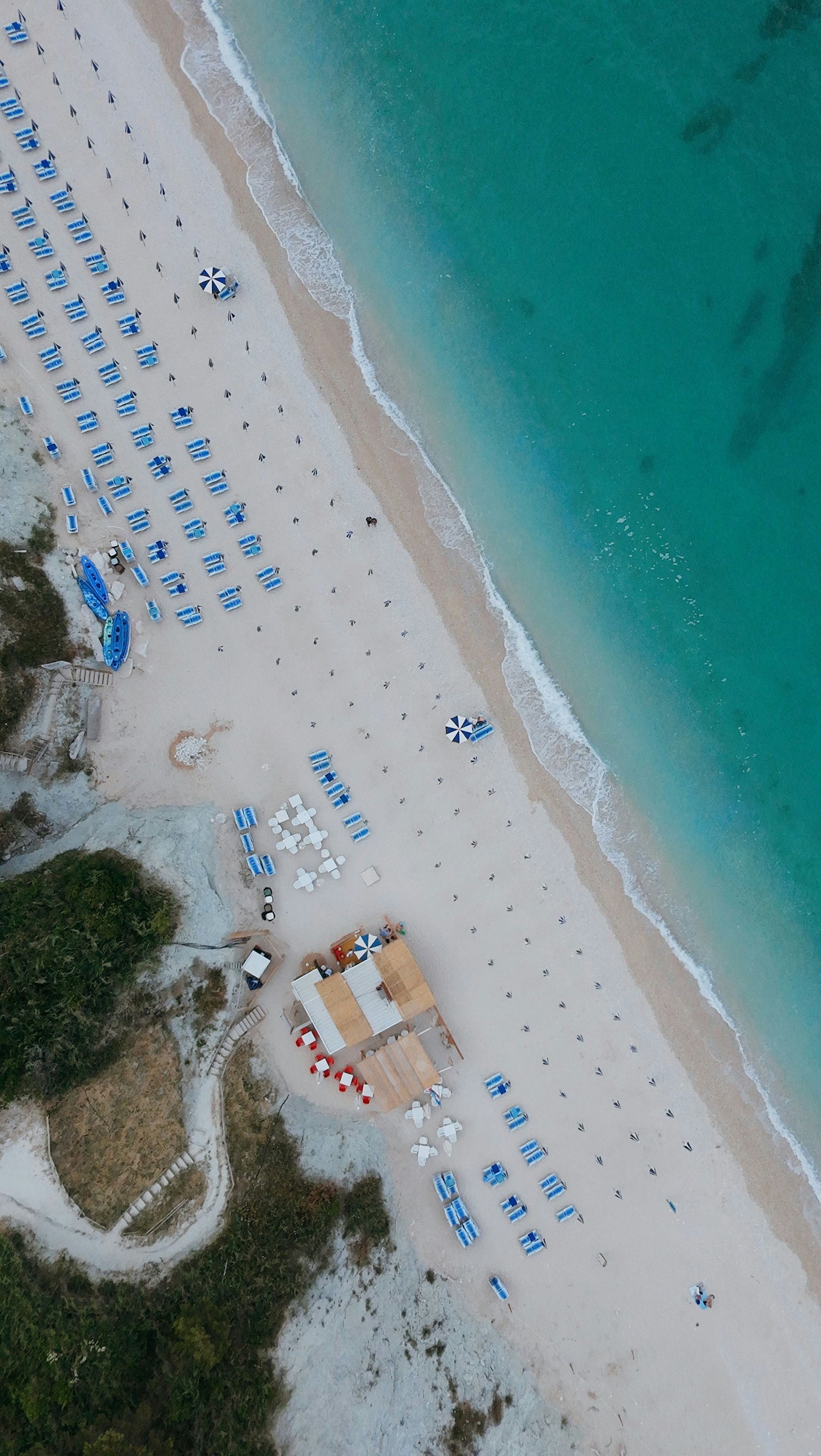 An aerial view of a beach with umbrellas and chairs in Sirolo, Italy.