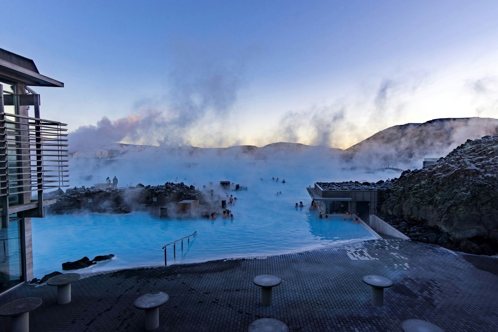 Blue Lagoon geothermal spa in Iceland with people in turquoise water, steam rising.