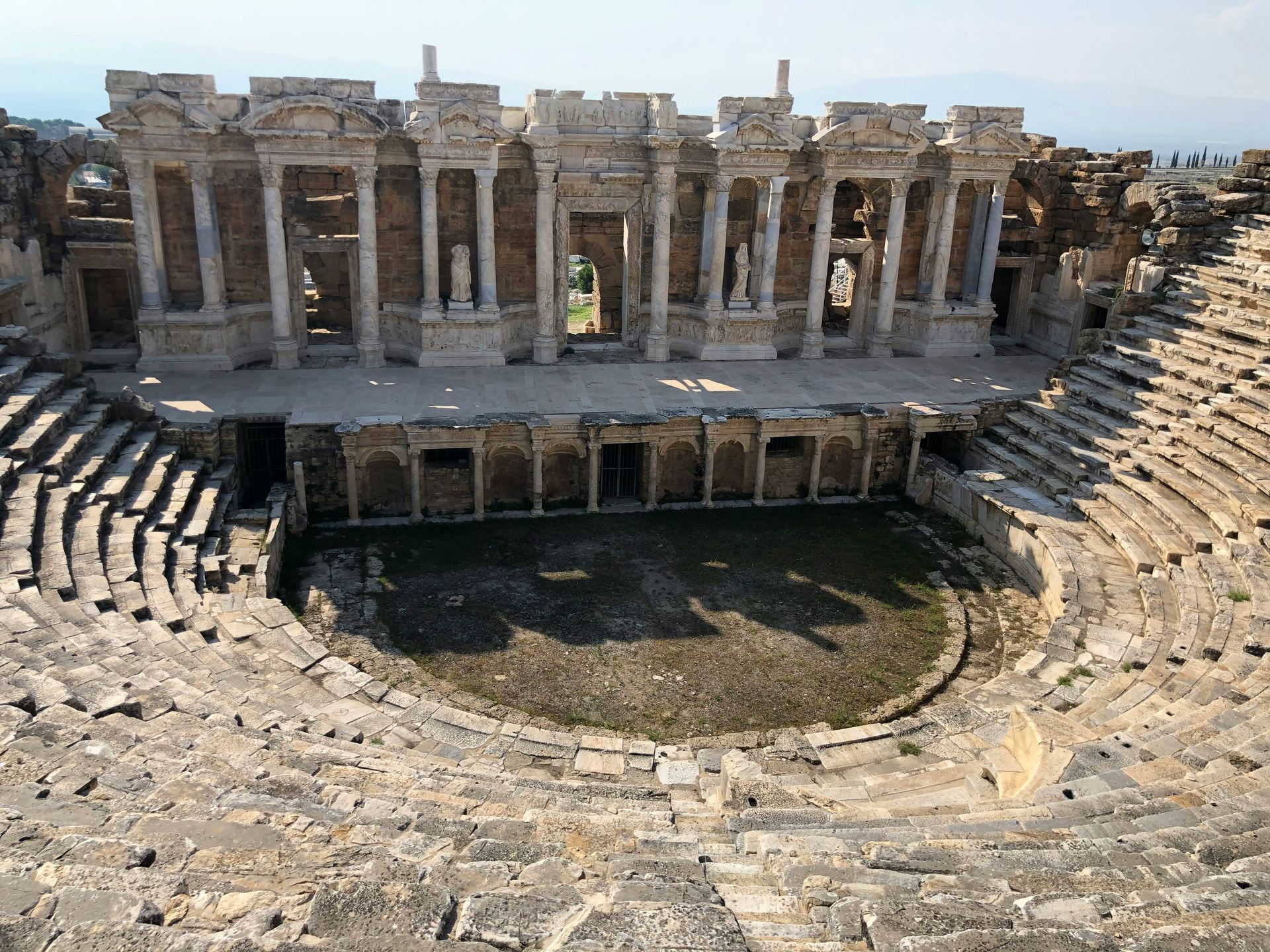 Ancient Roman theater ruins in Hierapolis, Turkey. Stone structure with columns, seating, and stage.