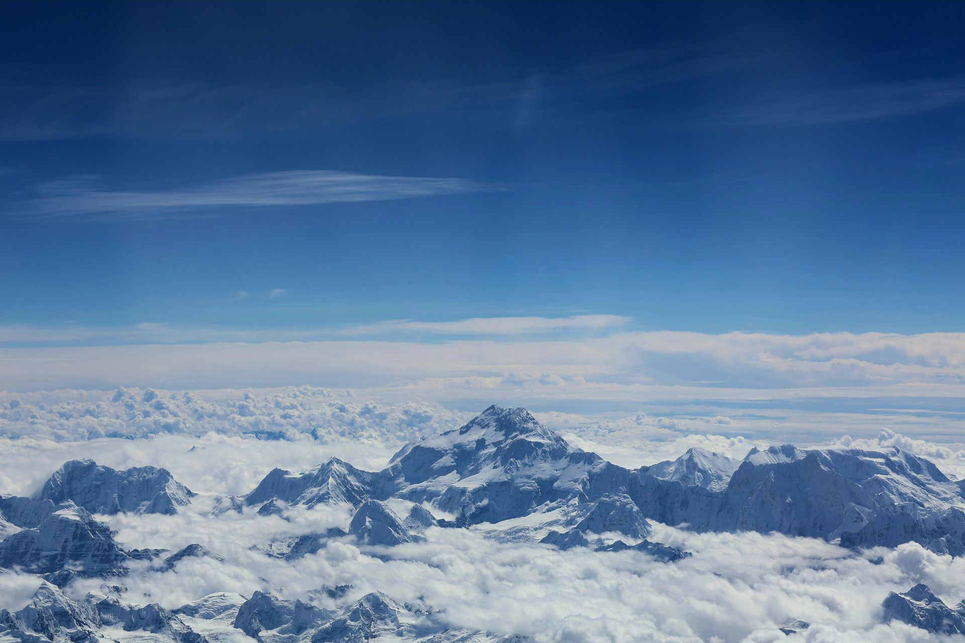 Snow-covered mountain range peaks rise above a sea of clouds in Sagarmatha, Nepal.