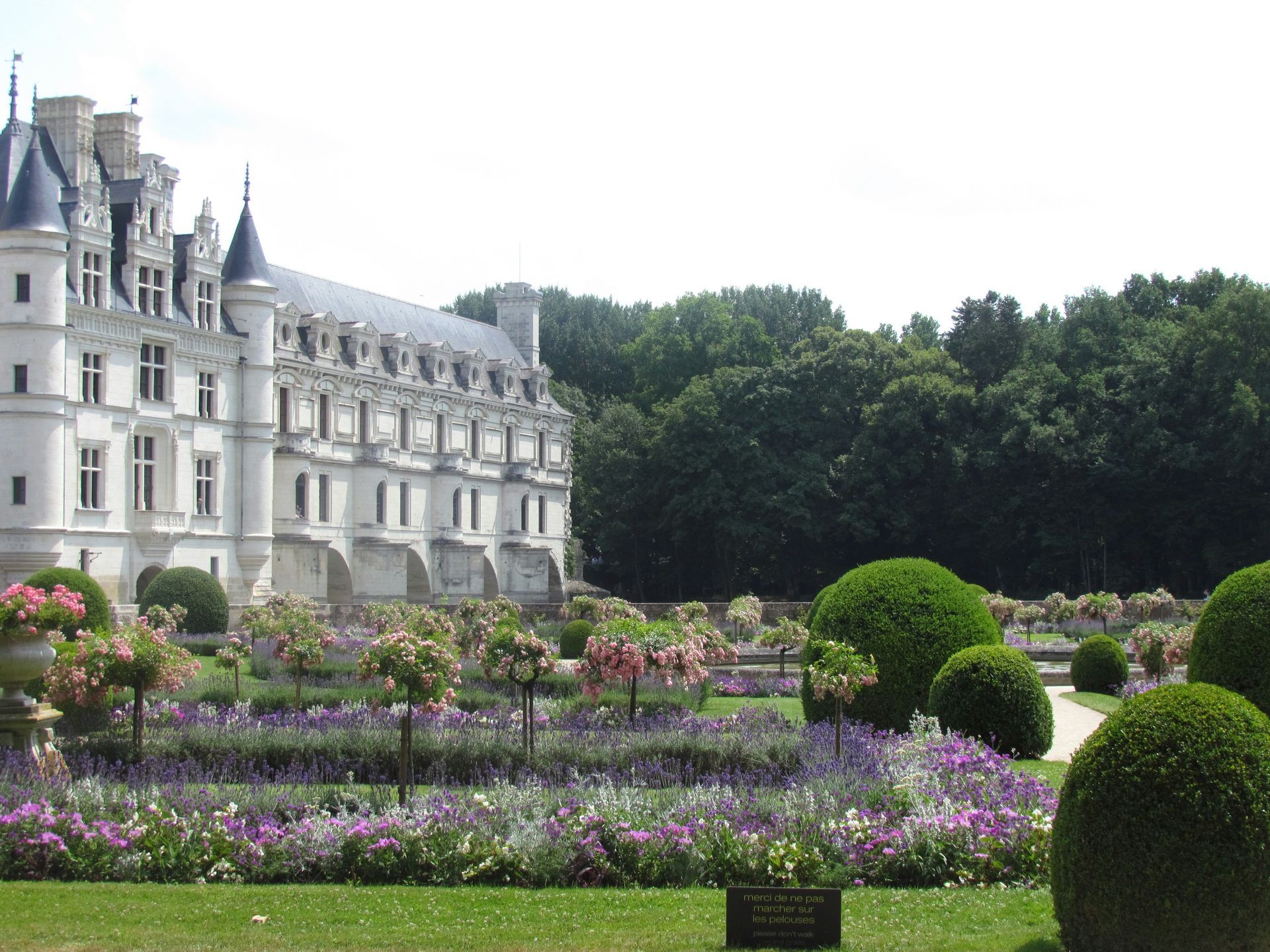 A large white building with the Château de Chenonceau in the background in France.